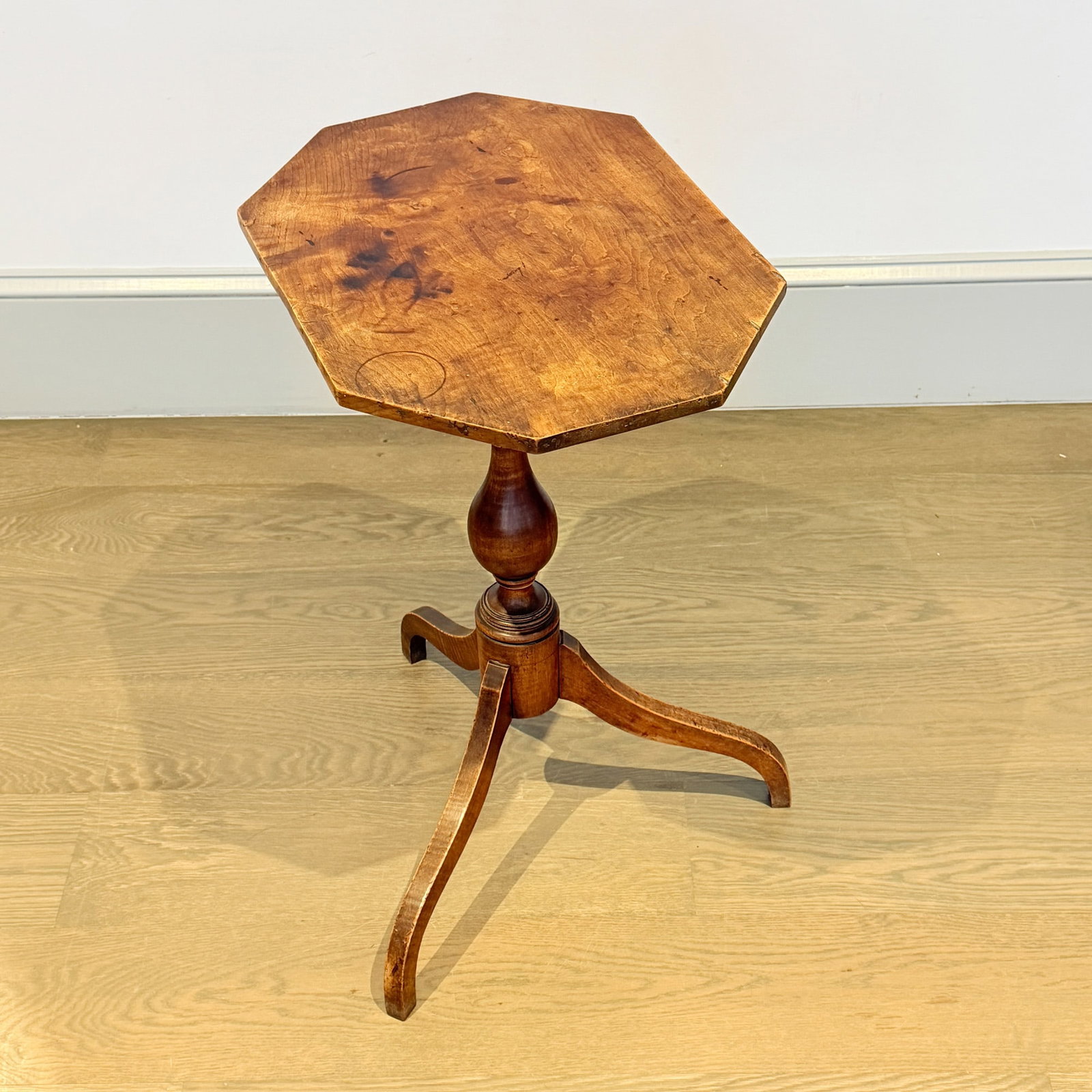 Federal Maple Candlestand: New England, early 19th century The octagonal top above a boldly turned post and tripod base of square tapering legs. Height 27 1/2 inches, width 20 inches, depth 14 1/4 inches.