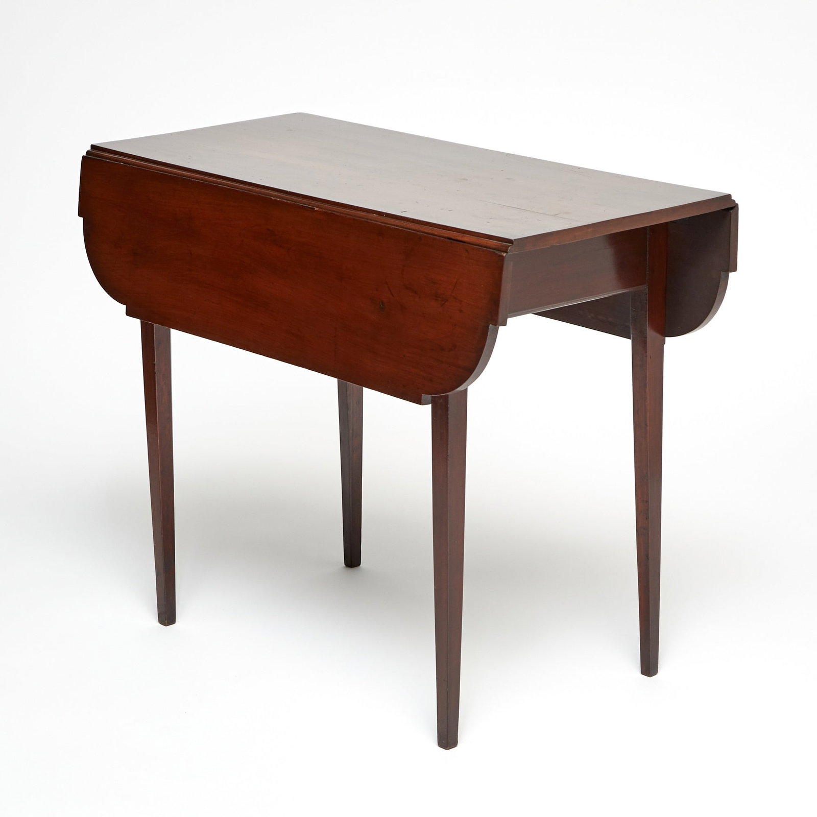 Federal Cherry Drop-Leaf Table: Connecticut or Massachusetts, circa 1790 The rectangular top with shaped leaves, raised on tapering square legs joined by a beaded apron. Height 28 3/4 inches, width 36 inches, depth 17 3/4 inches.