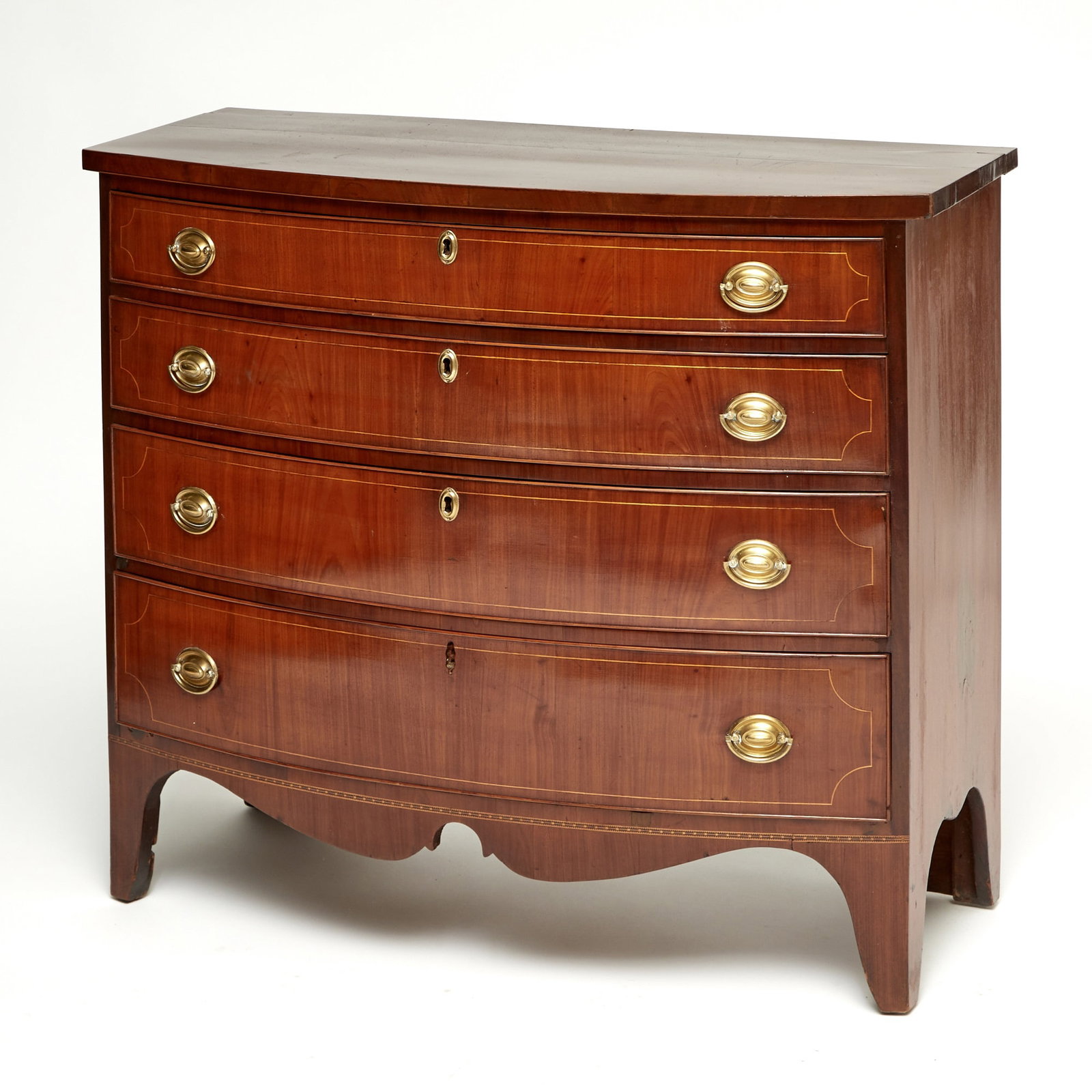 Federal Inlaid Mahogany Bowfront Chest of Drawers: Probably New England, early 19th century With four cockbeaded graduated and string-inlaid drawers, above a shaped apron, raised on flared feet. Height 35 inches, width 41 inches.