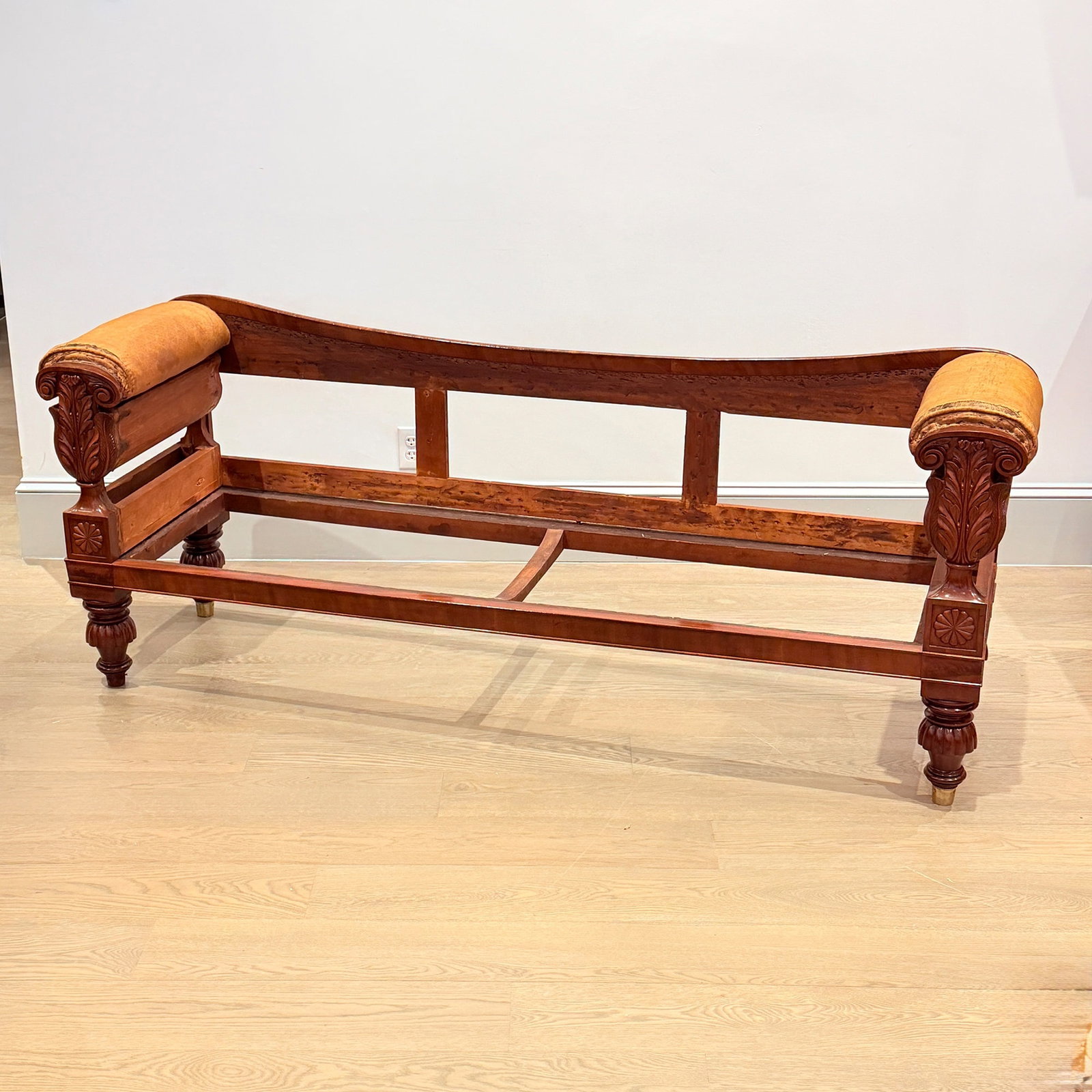 Classical Mahogany Sofa Frame: Possibly Henry Hancock, Boston, Massachusetts, 1823-27, the carving attributed to Thomas Wightman. Each arm facing with a scrolled crest above leaf carving, raised on turned partially reeded feet