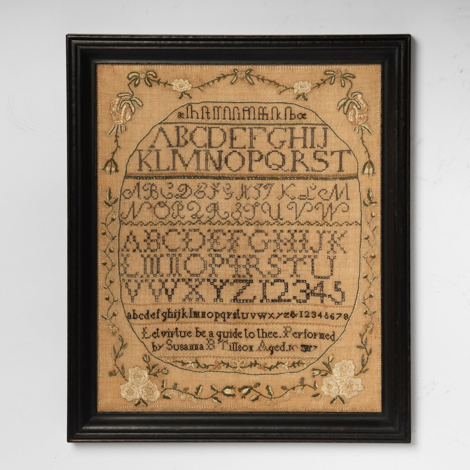 Needlework Sampler "Susanna B. Tillson": Plymouth, Massachusetts, 1817 Worked in silk threads on a coarse linen ground, designed as a central oval with alphanumeric lines in a variety of stitches above the maker's name, with a meandering