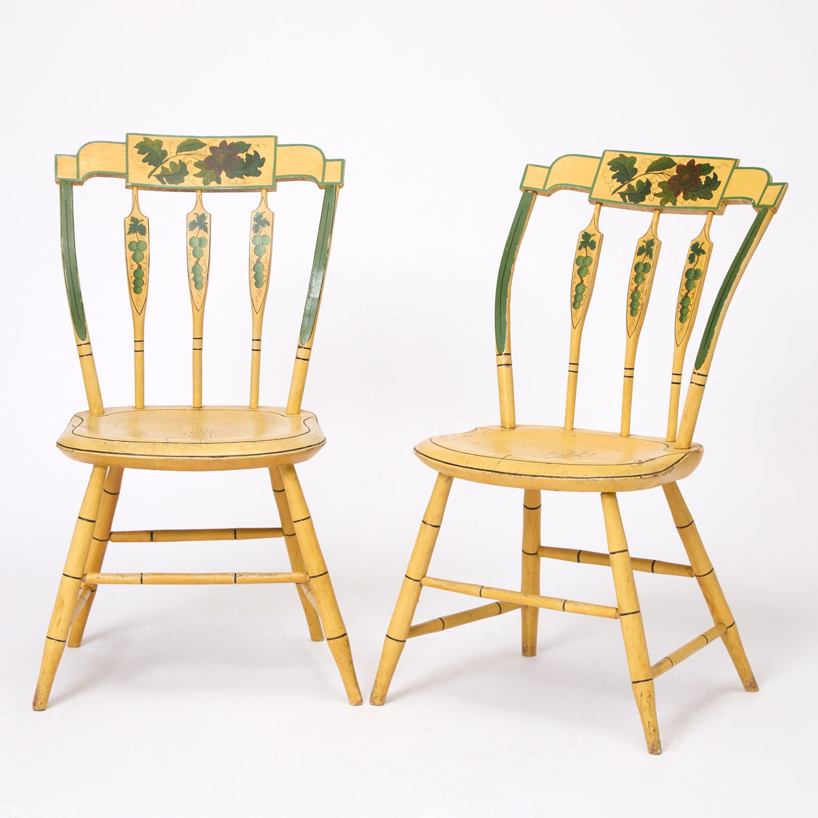 Pair of Yellow Painted Windsor Side Chairs: New England, early 19th century Each step-down tablet centering a floral spray, above three arrow-form spindles and bowed green-painted stiles, all raised on bamboo-turned legs and stretchers. Height