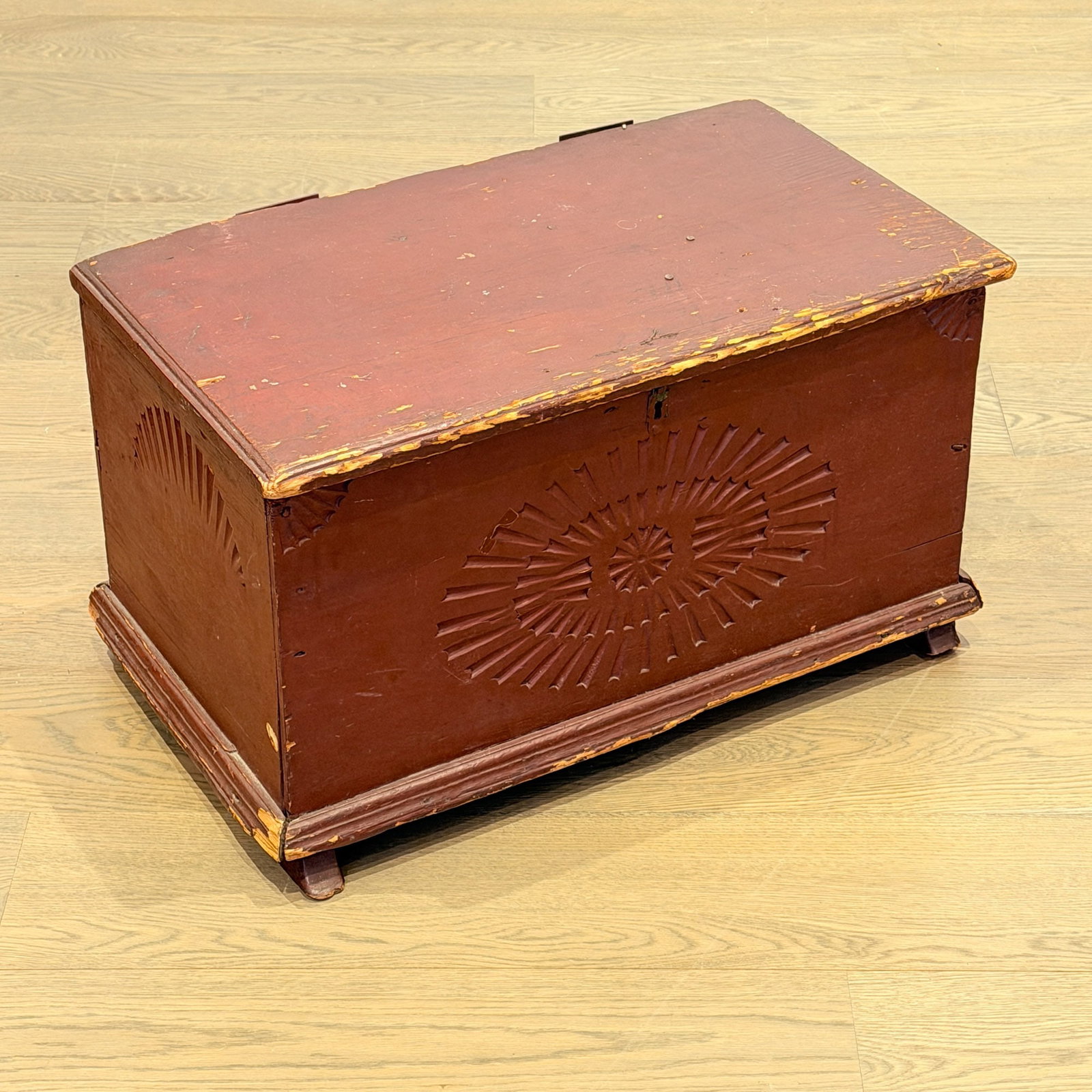 Red Painted and Carved Pine Storage Trunk: Probably New Hampshire, late 18th century The molded hinged lid above a box with carved paterae and fans. Height 14 3/4 inches, width 25 1/2 inches, depth 14 inches