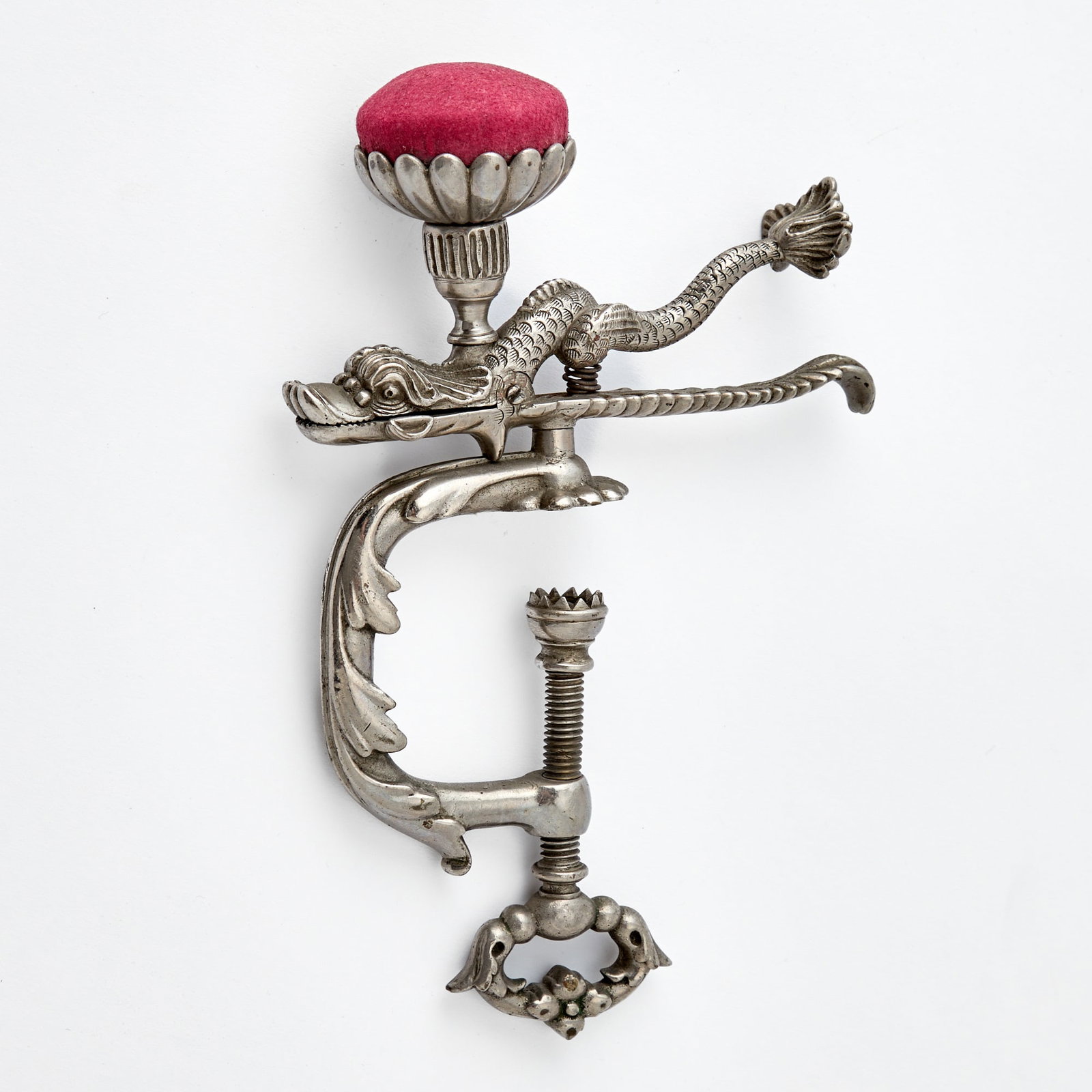 Steel Dolphin Sewing Clamp: Mid 19th century With a pin cushion. Height 7 1/2 inches.
