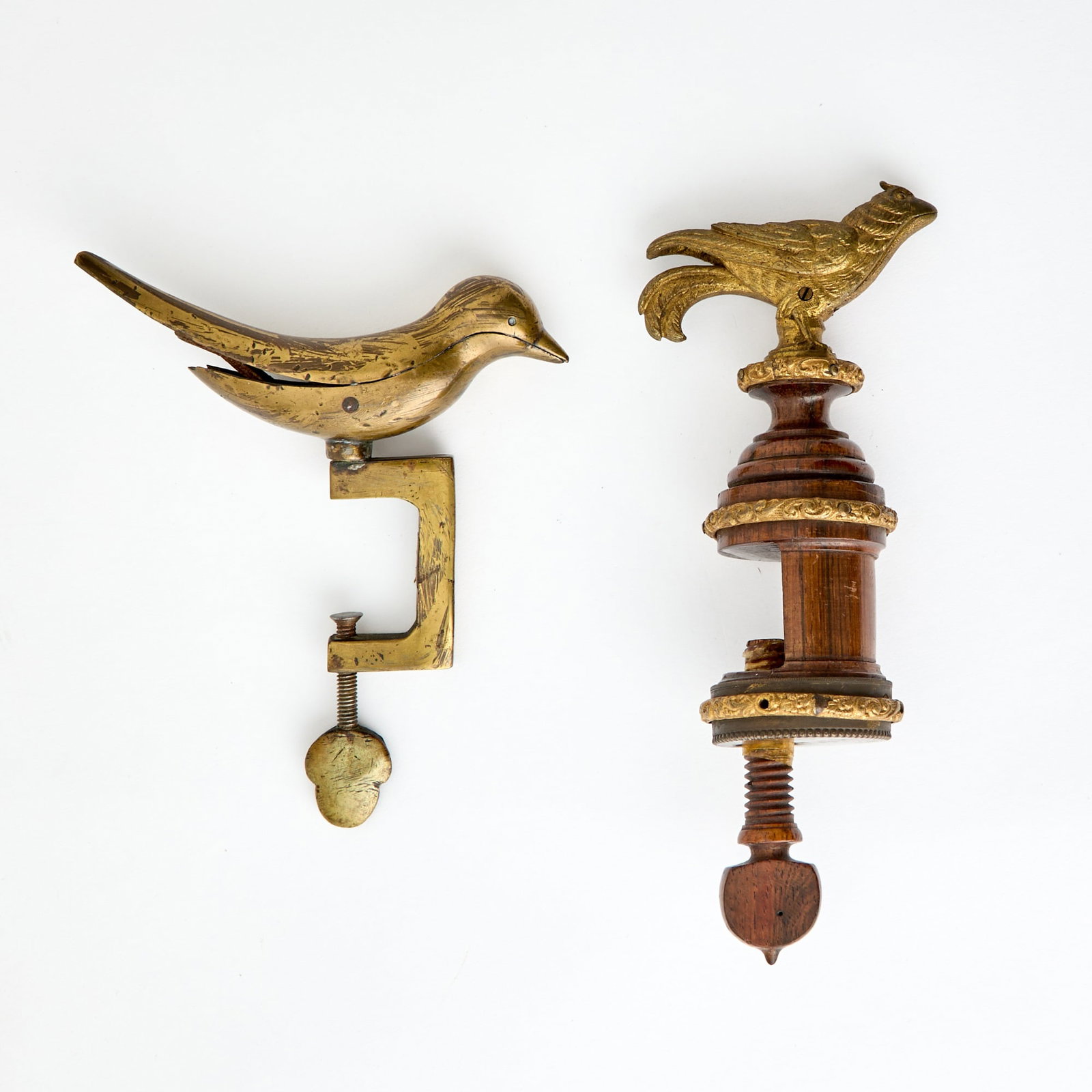 Two Bird Form Sewing Clamps: Second half 19th century Comprising a brass example, height 6 inches; and a gilt-bronze and walnut example, height 8 inches.