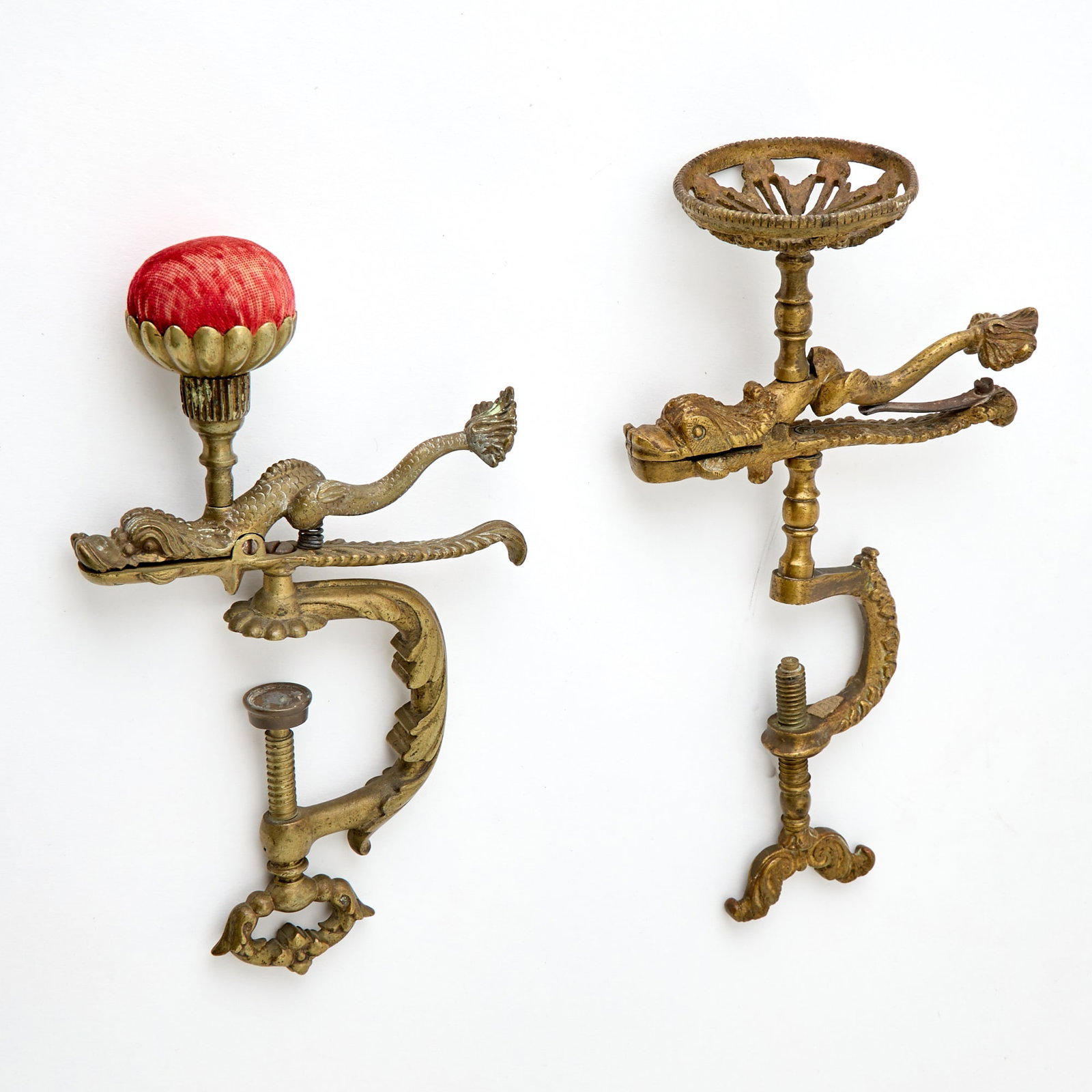 Two Gilt Brass Dolphin Sewing Clamps: Second half 19th century One lacking pin cushion. Height of taller 9 1/2 inches.