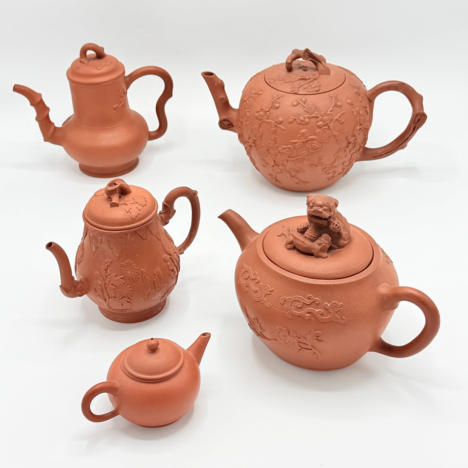 Group of Five Staffordshire Redware Teapots: England, late 18th century Most with molded decoration. Height of tallest 6 1/4 inches, diameter of largest 6 inches.