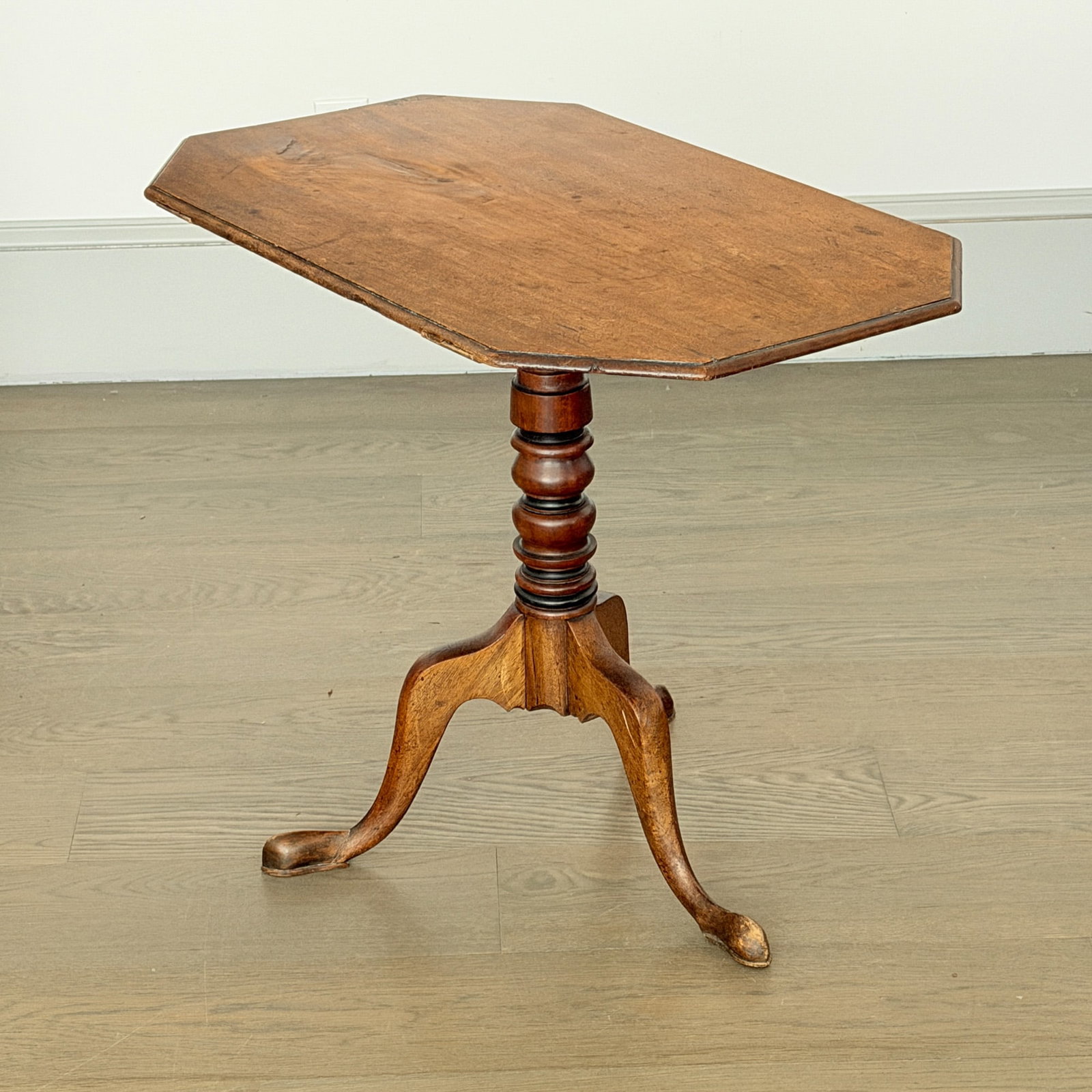 Federal Octagonal Tilt-top Candlestand: New England, early 19th century The molded top tilts on a vase and ring-turned post Height 25 inches, width 30 1/2 inches, depth 19 1/2 inches.