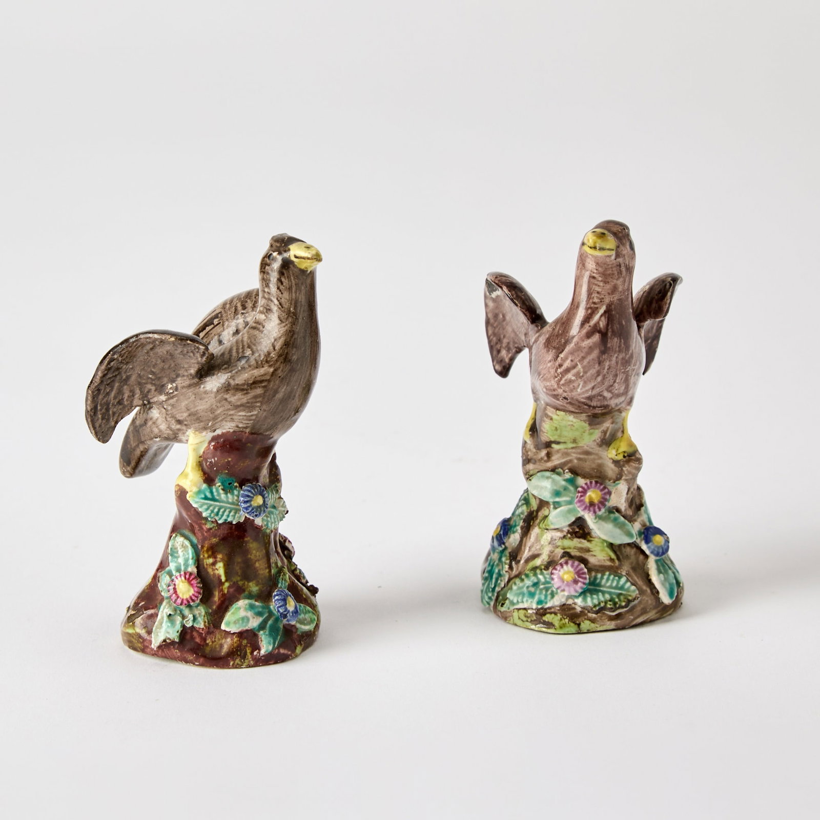 Pair of Staffordshire Pearlware Small Figures of Eagles: Circa 1825-1830 Each modeled with wings spread, perched on a rocky base applied with flowers and leaves. Height 3 1/2 inches.