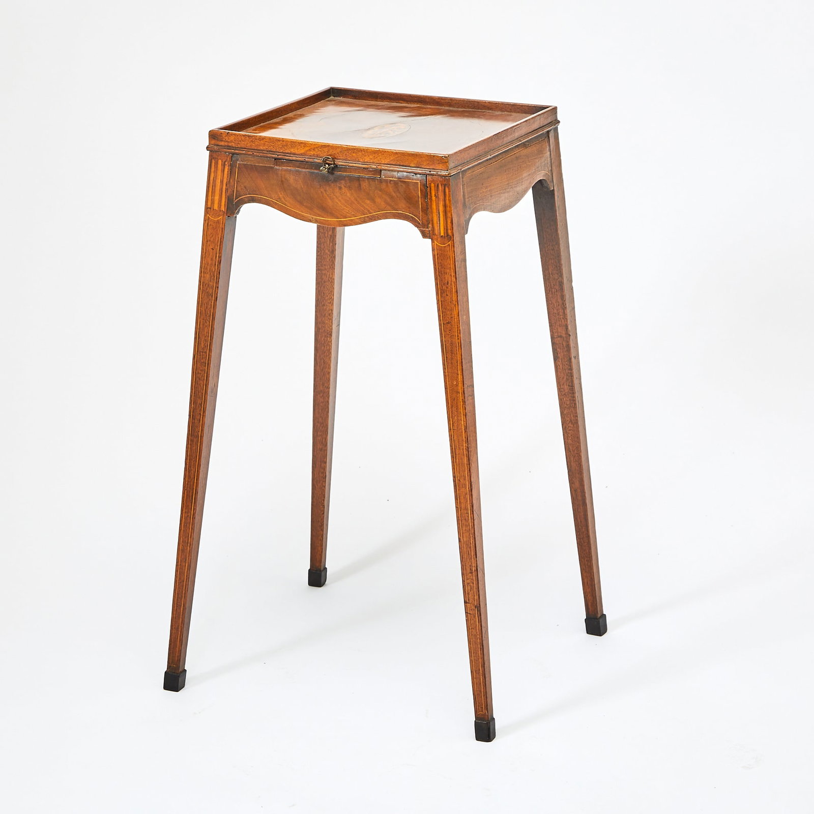 George III Mahogany Satinwood Marquetry-Inlaid Kettle Stand: Circa 1790 The square top with oval shell inlay above a candle slide and serpentine-shaped apron, on tapering square legs; with ivorine label Stair & Co. / Williamsburg, VA. Height 27 3/4 inches, 