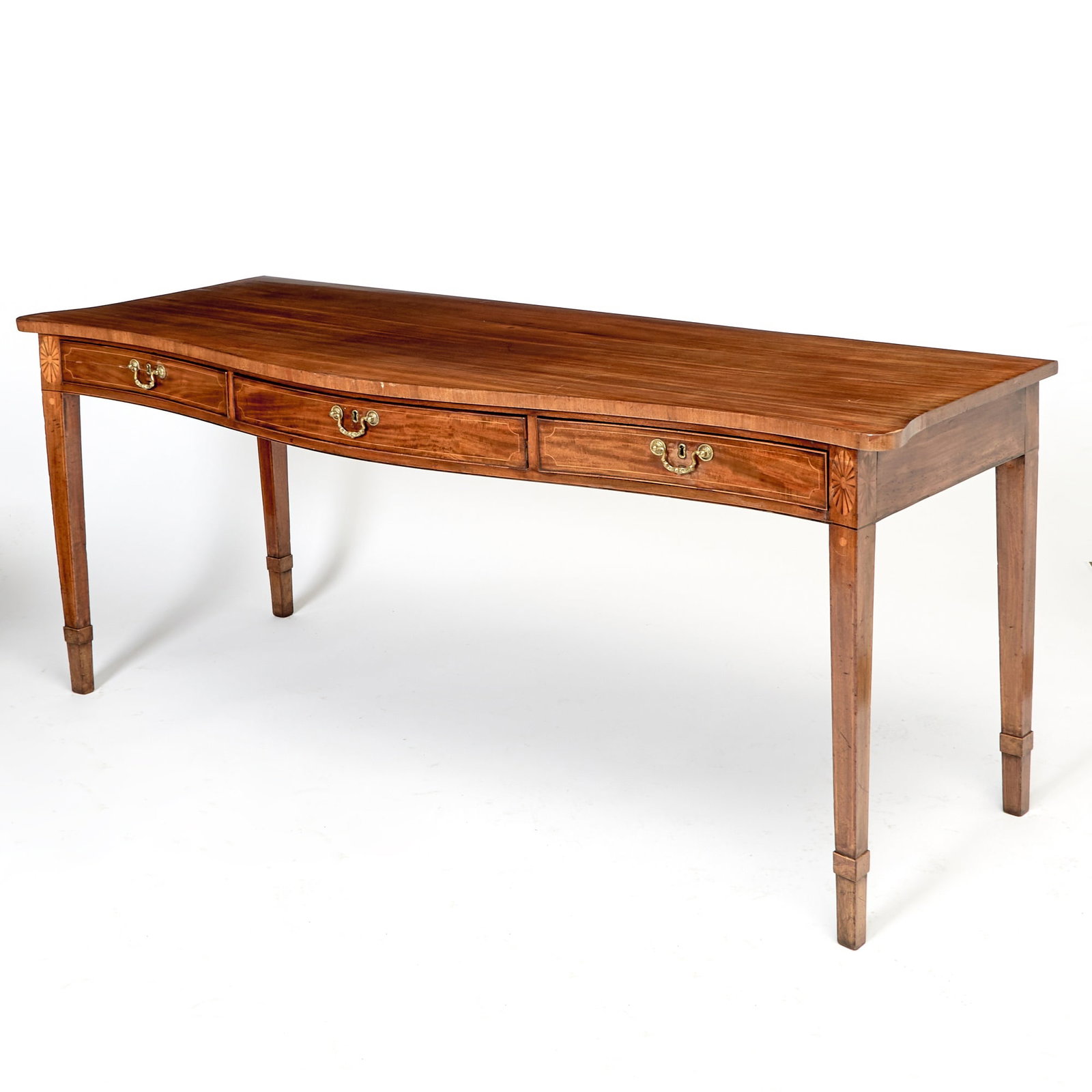 George III Inlaid Mahogany Serving Table: Late 18th/early 19th century Of serpentine form, with three frieze drawers, raised on tapering square legs. Height 34 inches, width 6 feet 10 inches, depth 29 inches.