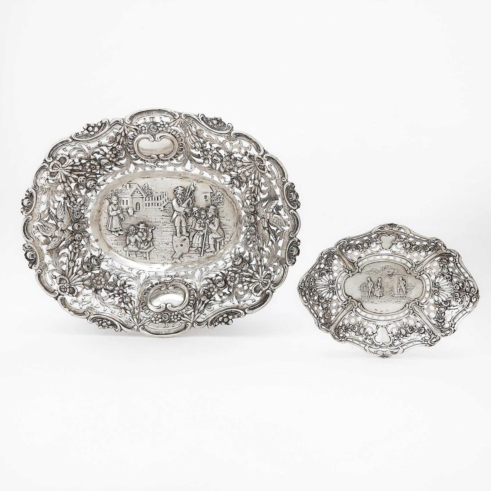 Two Continental Silver Dishes: Late 19th/early 20th century Each with a pierced body, the field chased with figural scenes. Lengths 11 inches and 6 inches, total approximately 15 ounces. Qty: (2)