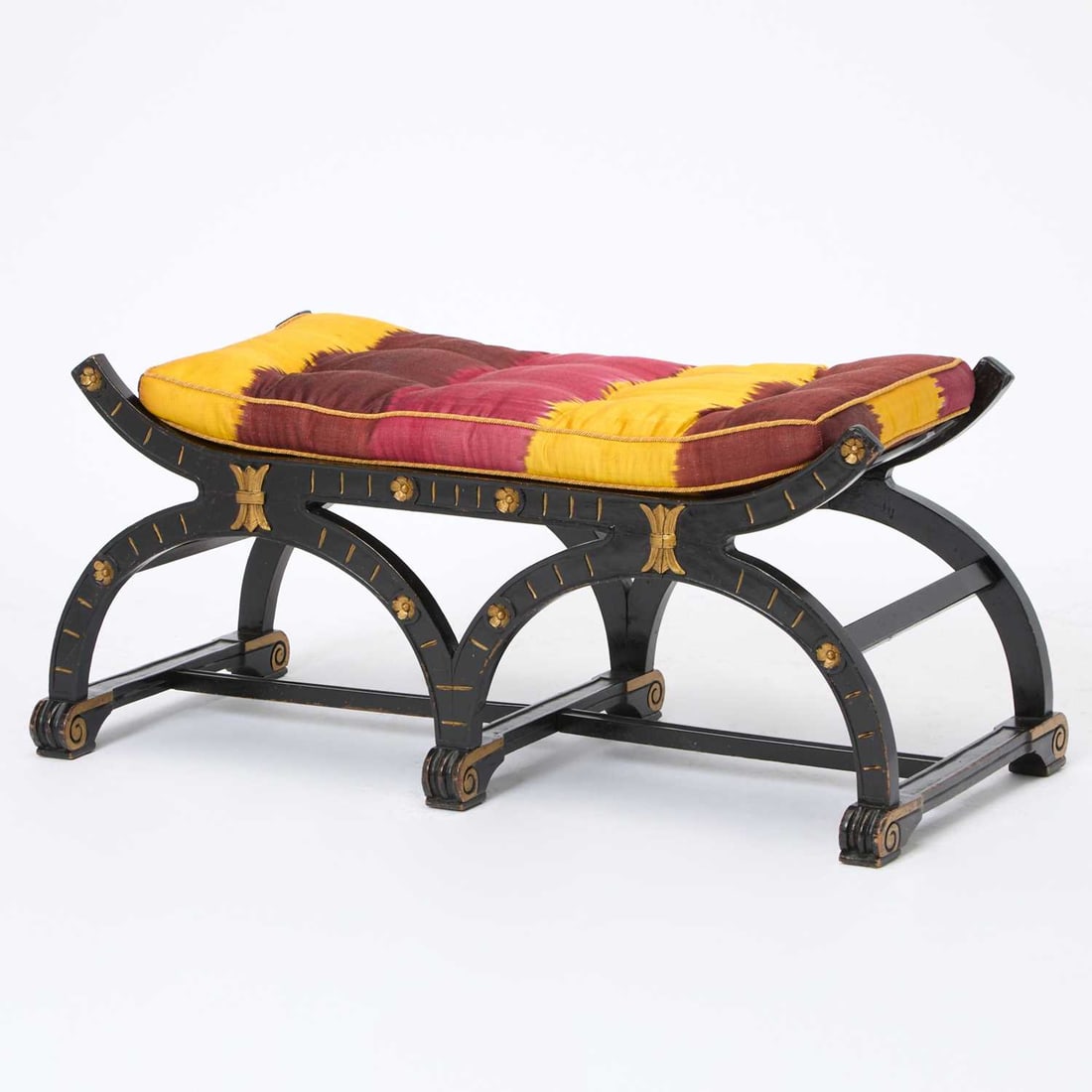 Regency Style Parcel Gilt and Ebonized Wood Double Curule Bench: The cushion with handwoven Ikat upholstery. Height 16 inches, length 40 inches, depth 17 inches. Provenance: Miles Redd, 2000s