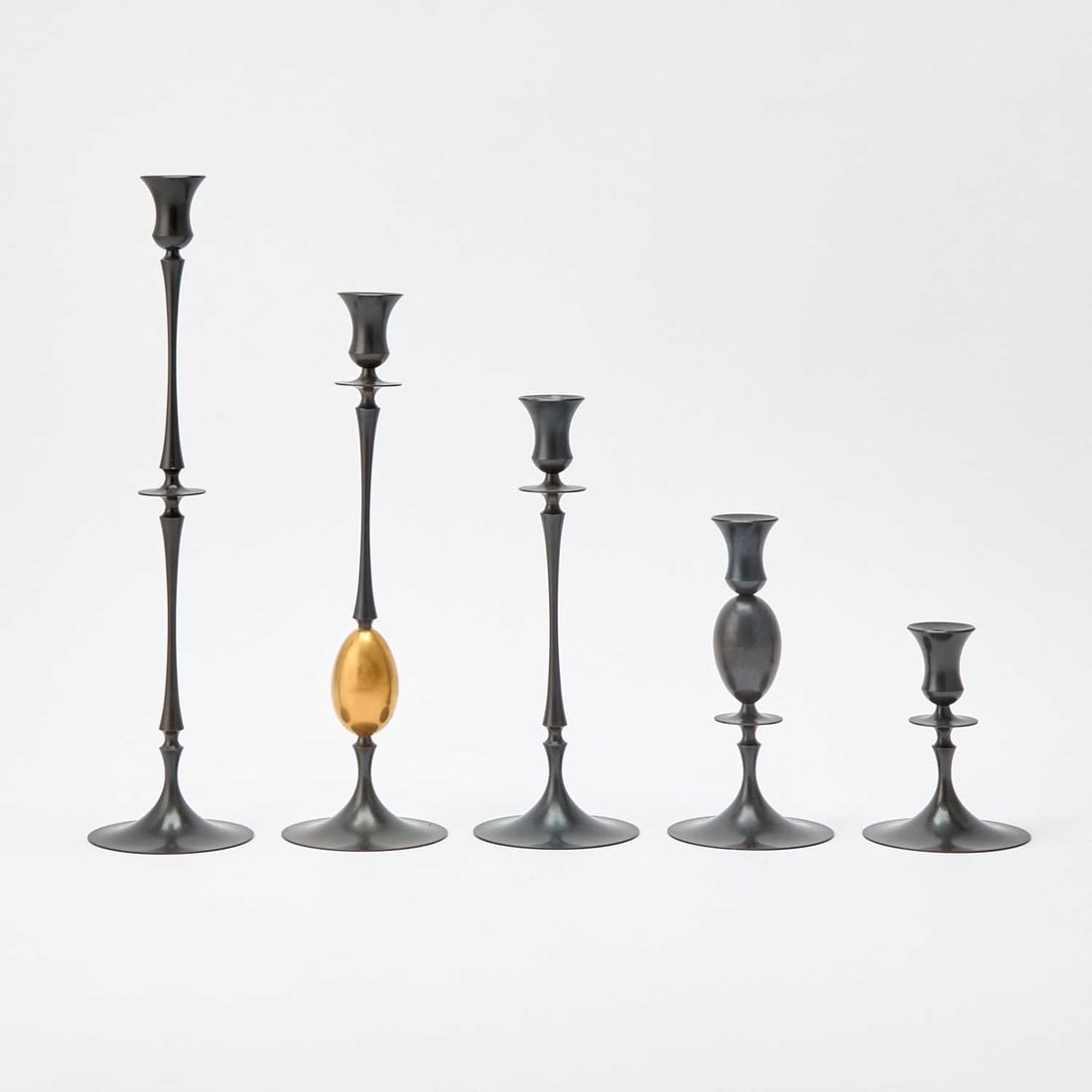 Five Ted Muehling Patinated Bronze Candle Holders: In various shapes and sizes, each impressed on the underside MUEHLING. Height of tallest 12 1/4 inches.