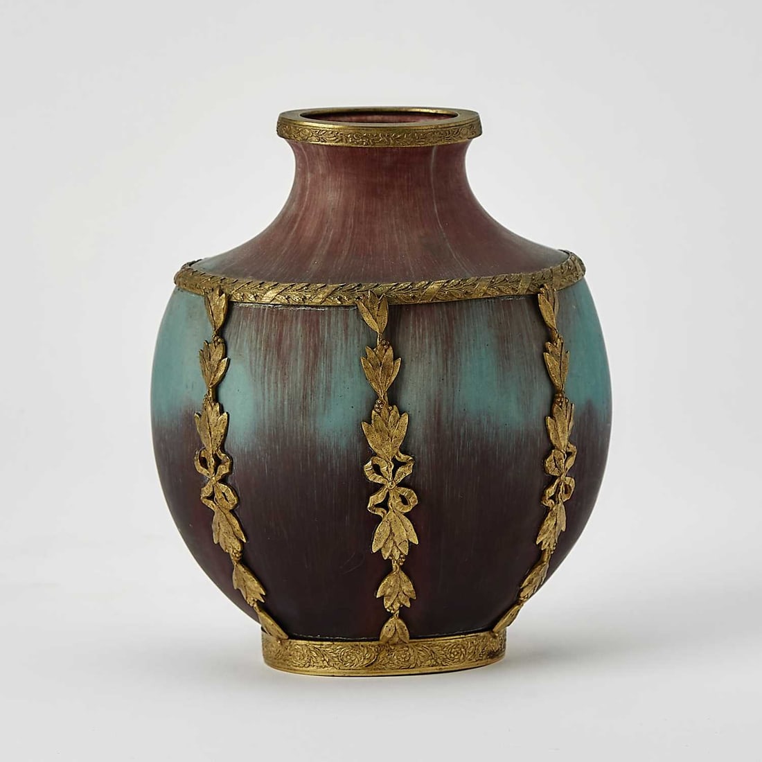 Eugène Baudin Art Nouveau Gilt-Brass Mounted Maroon and Turquoise Glazed Stoneware Vase: Late 19th/early 20th century Of flattened urn form, with a waisted neck and oval mouth, glazed in striated maroon/oxblood and turquoise colors, incised on the underside Baudin. Height 6 1/8 inches, wi
