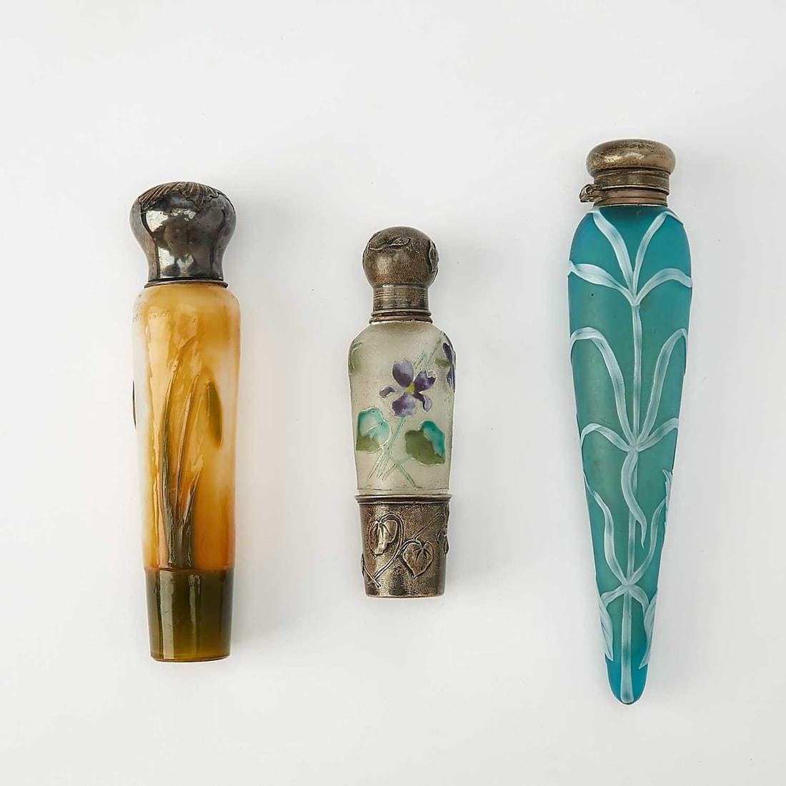 Three Metal-Mounted Cameo Glass Scent Bottles: Late 19th/early 20th century Comprising an English silver mounted acid-etched and wheel-engraved example, with stylized floral decoration, in blue and white colors, unsigned, length 6 1/2 inches; a Fr