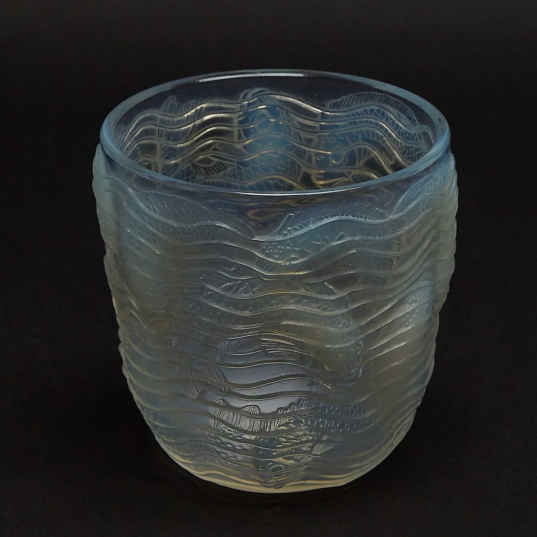 R. Lalique Molded Opalescent Glass "Dauphins" Vase: Marcilhac no. 10-900, circa 1932-47 Of circular form, molded with dolphins and waves, in relief, acid-stamped R. LALIQUE and engraved France. Height 5 1/2 inches, diameter 5 1/4 inches.