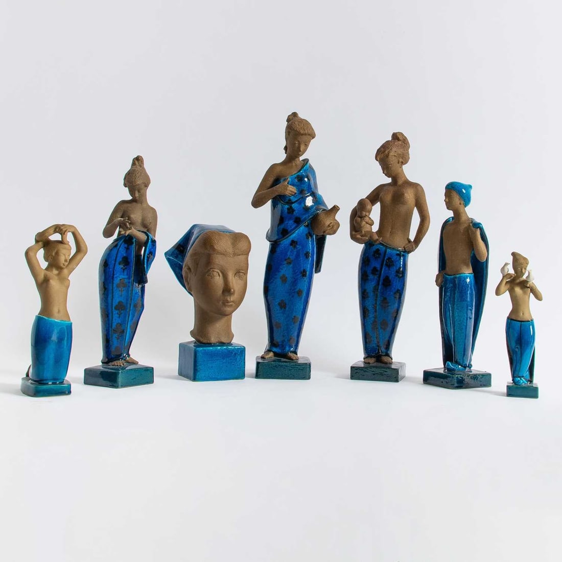 Seven Royal Copenhagen Parcel Glazed Stoneware Figures: Designed by Johannes Hedegaard (1915-1999), circa 1960 Including a young seminude woman, modeled standing and holding an infant, a young seminude woman,