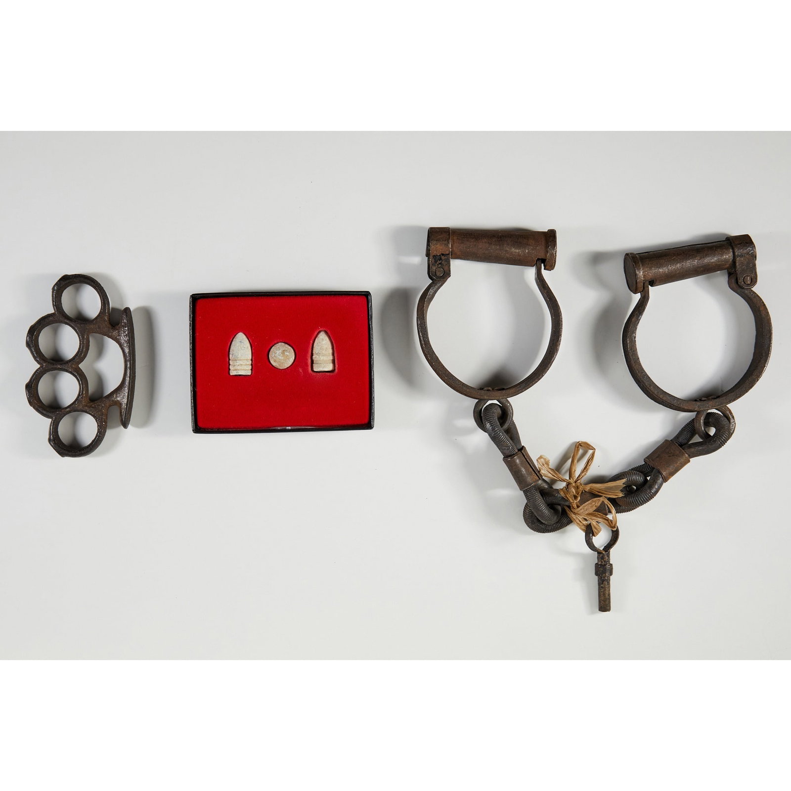 Intriguing group of Civil War era artifacts: [CIVIL WAR- ARTIFACTS] A pair of iron shackles, cast iron knuckles, and set of three bullets. [Mid 19th cen