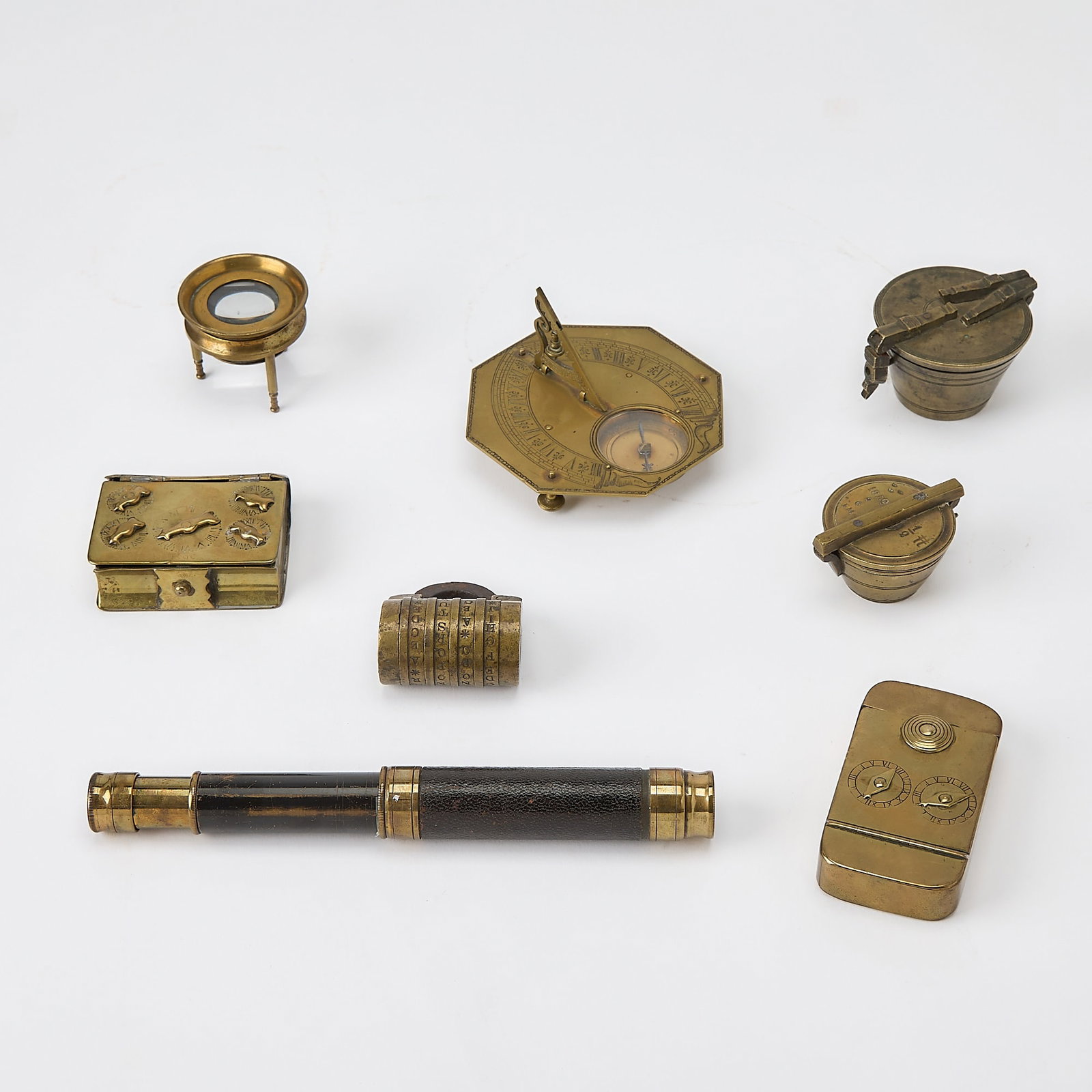 Eight brass objects: [OBJECTS] Small brass objects, including a Dolland spyglass, combination lock, and sundial compass. 8 total objects. [Likely 20th century] The largest 3 1/2 x 2.5 (9 x 6.5 cm), heaviest approximately 