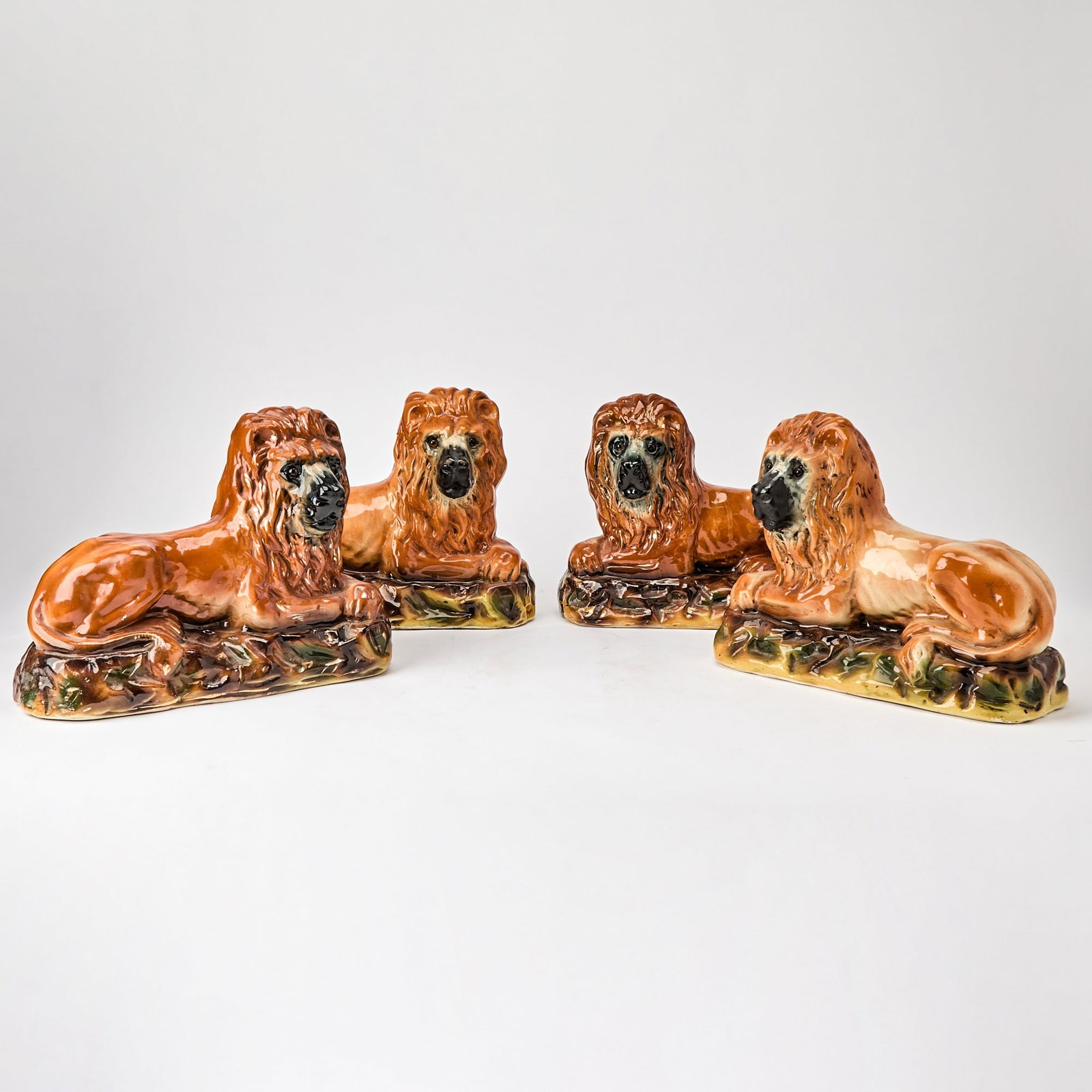 Set of Four Staffordshire Pottery Recumbent Lions: Late 19th century Height 9 1/2 inches, width 13 inches, depth 5 inches.