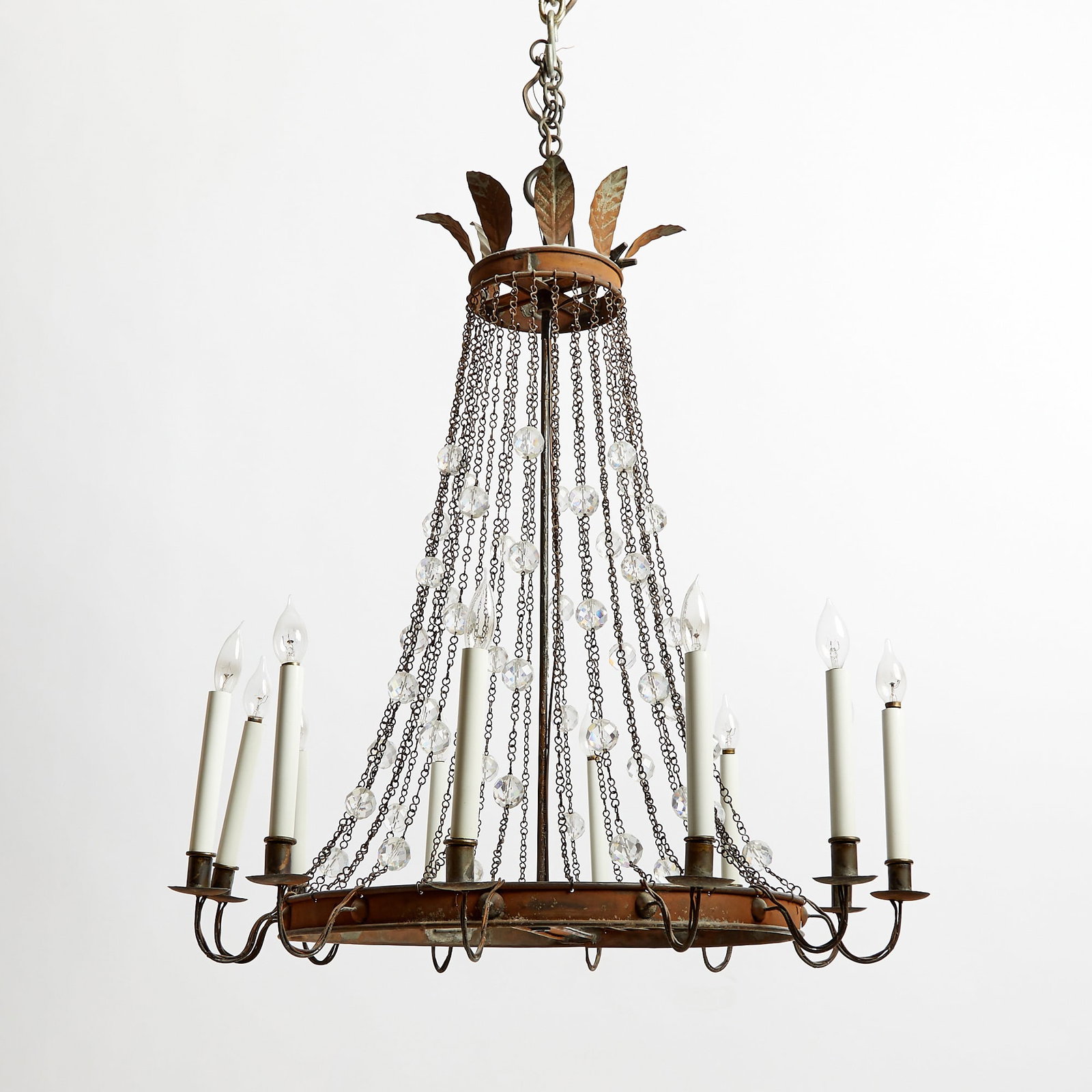 Empire Style Patinated Metal Cut-Glass Twelve-Light Chandelier: 19th Century The circular corona applied with leaves and suspending chain-link swags with faceted glass beads, the circular metal ring issuing scrolling branches. Height 32 inches, diameter 30 inches.