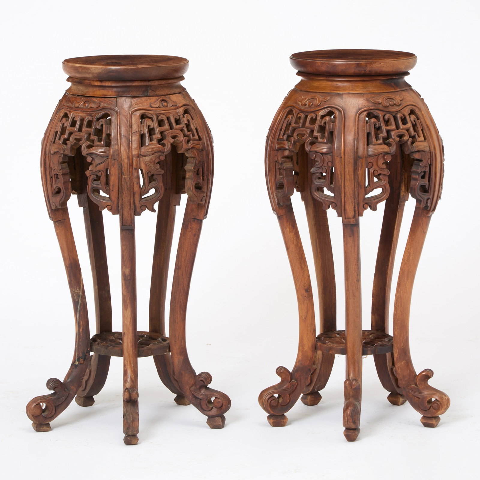Pair of Asian Carved Hardwood Pedestals: 20th Century Height 33 1/2 inches, diameter 15 1/2 inches. shrinkage cracks on some carving