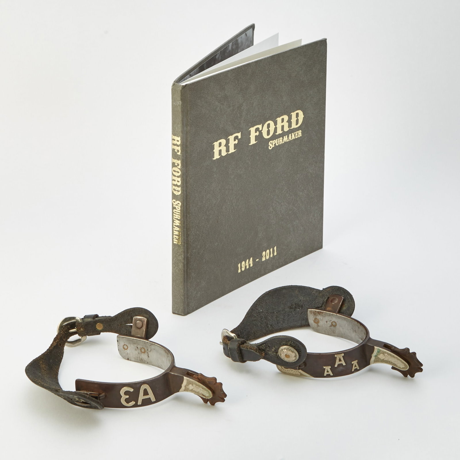 Pair of R.F. Ford Silver, Iron and Leather Bespoke Spurs: Made for Roy Hauser of High Point, North Carolina Length 5 1/2 inches, width 3 1/2 inches. Sold together with a copy of R.F. Ford Spurmaker 1944-2011 by Liz Ford, 2012
