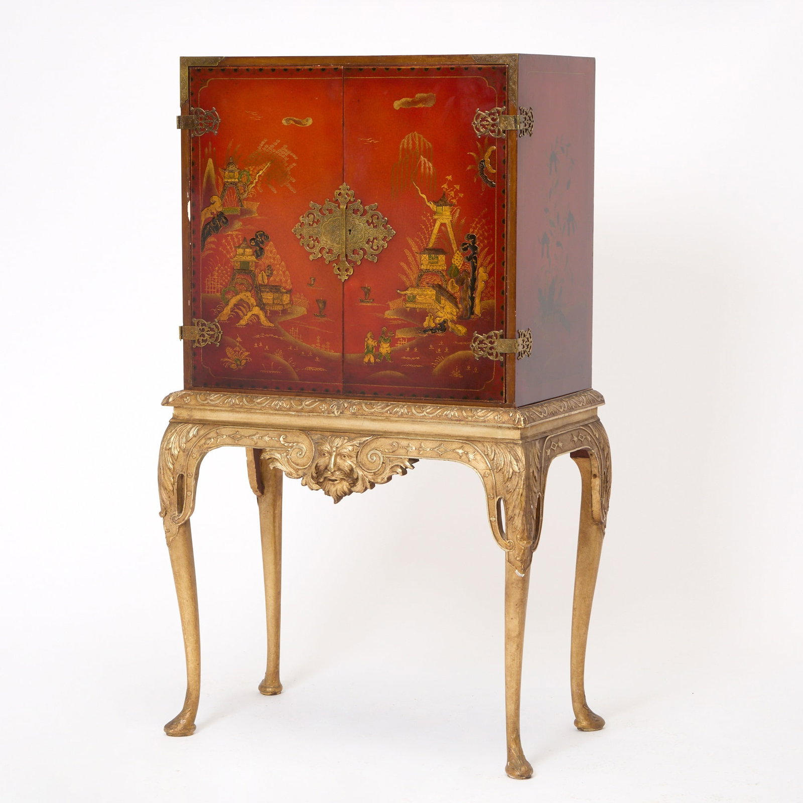 George I Style Chinoiserie Decorated Red Lacquer Cabinet on a Gilt Stand: Early to mid 20th century With two original shelves and two later shelves. The cabinet sits on a silver-gilt base with central mask having carved and moulded frieze raised on shaped cabriole legs with