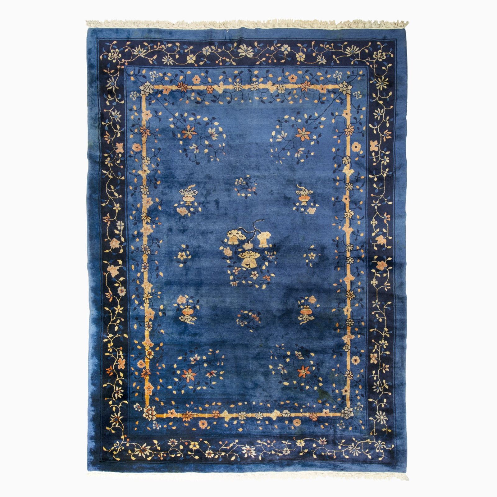 Peking Chinese Carpet: China, First 1/4 20th Century The indigo field with a central medallion flanked by flowering vases and sprays is within a midnight blue floral vinery border. (13' 4" x 9' 8") Stains, added machine