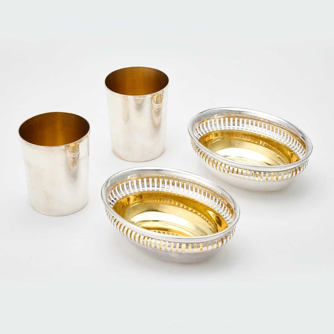 Pair of Italian Silver Bowls and Pair of Continental Silver Beakers: Late 20th century The pair of bowls with pierced rims, length 6 inches; height of beakers 3 5/8 inches, total approximately 18 ounces.