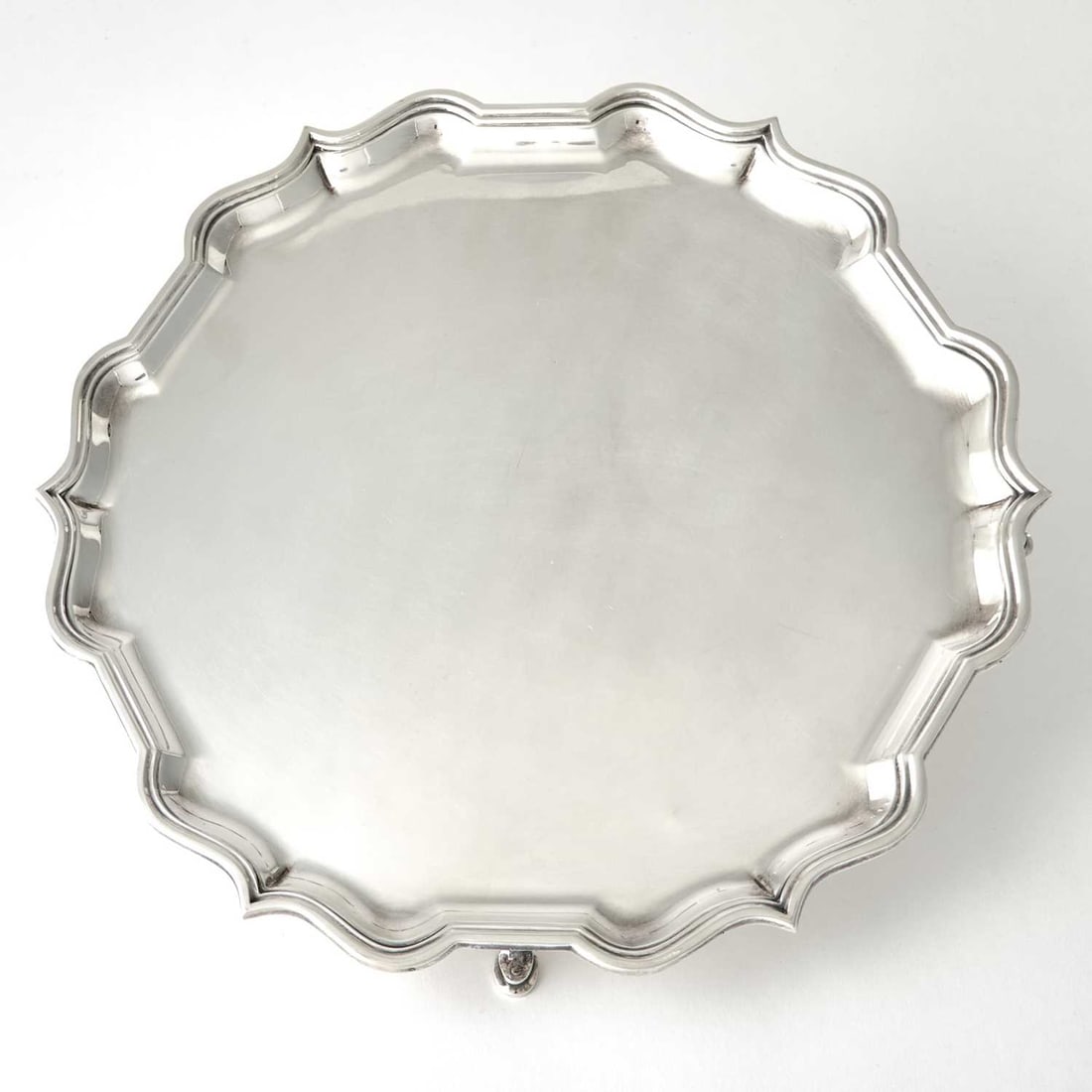 English Sterling Silver Salver: C.J. Vander, Sheffield, 1964 Shaped circular, raised on four hoof feet. Diameter 14 1/2 inches, approximately 39 ounces.