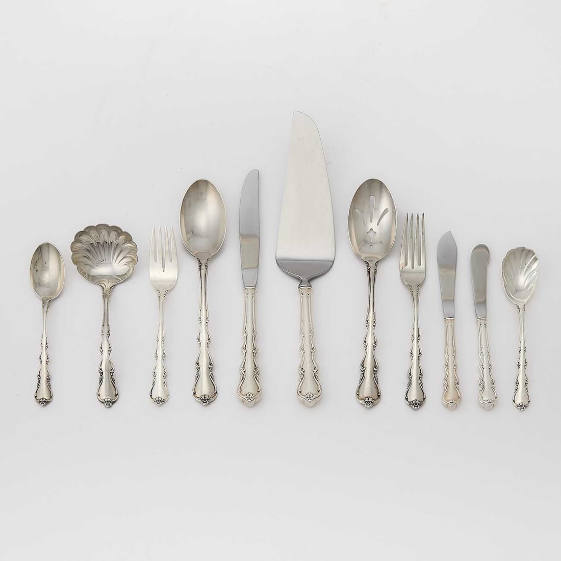 International Sterling Silver "Angelic" Pattern Flatware Service: Comprising: Twelve dinner forks Twelve salad forks Twelve dinner knives Twelve butter knives Twelve teaspoons Two serving spoons Two pierced serving spoons Gravy ladle Master butter knife Pie serv