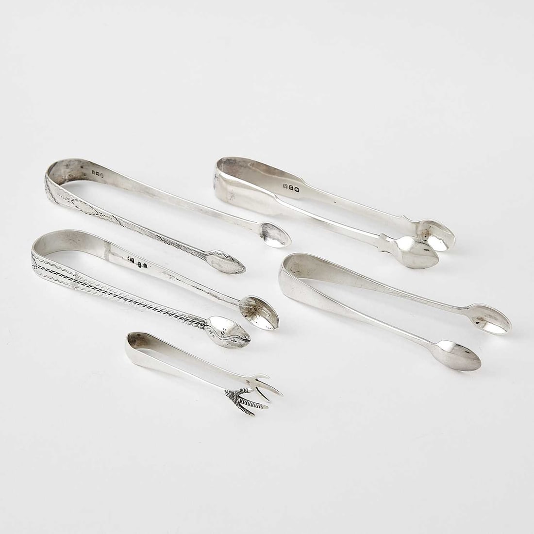 Large Collection of English Sterling Silver Sugar Tongs: Largely 19th century Approximately 26 pieces. Total approximately 30 ounces. Includes 4 engraved examples; majority are Georgian