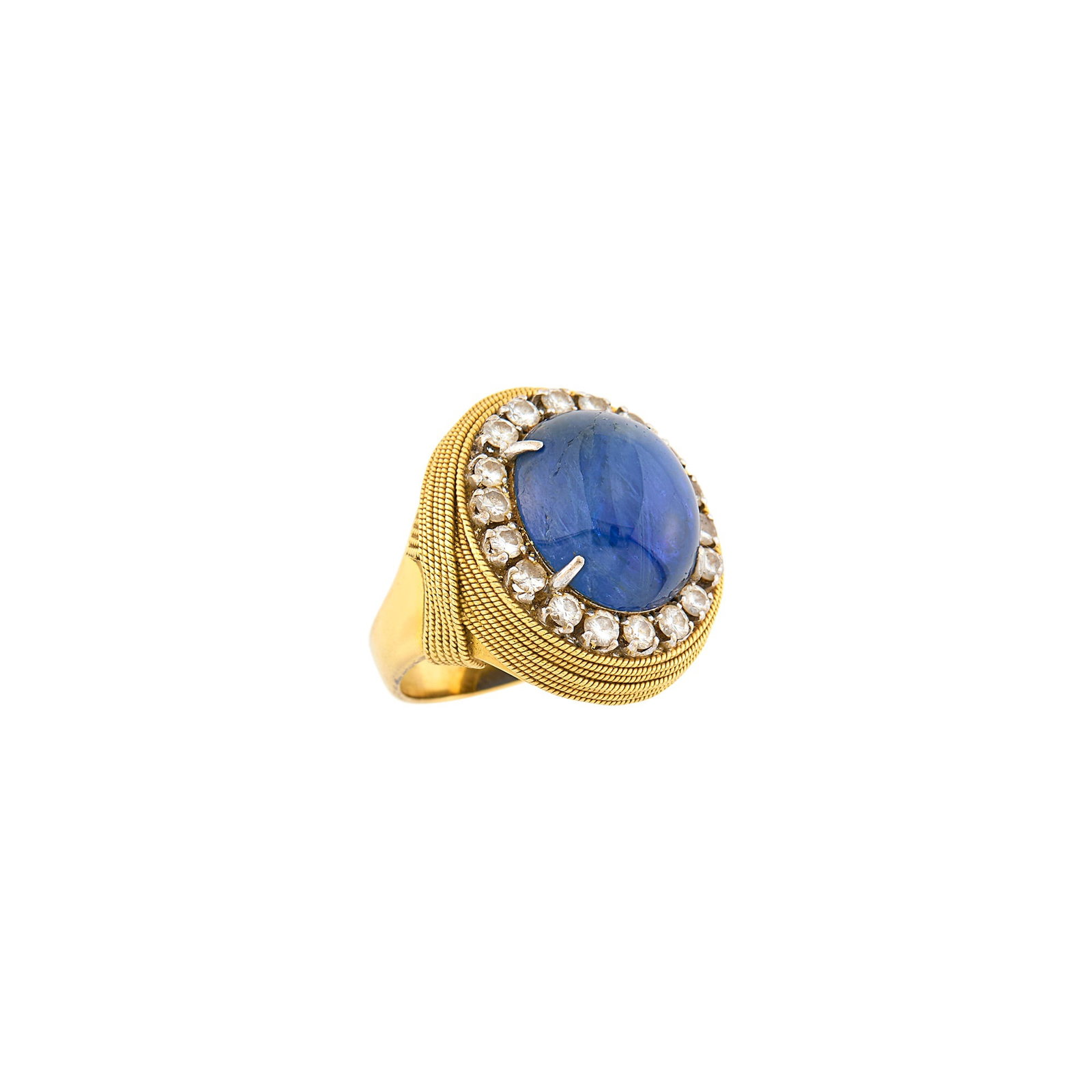 Gold, Platinum, Cabochon Sapphire and Diamond Ring: 18 kt., one oval cabochon sapphire ap. 18.50 cts., 18 round diamonds ap. 1.25 cts., ap. 14.3 dwts. Size 7 1/4. Sapphire: to the eye, deep slightly violetish blue, with a light, purplish blue with some