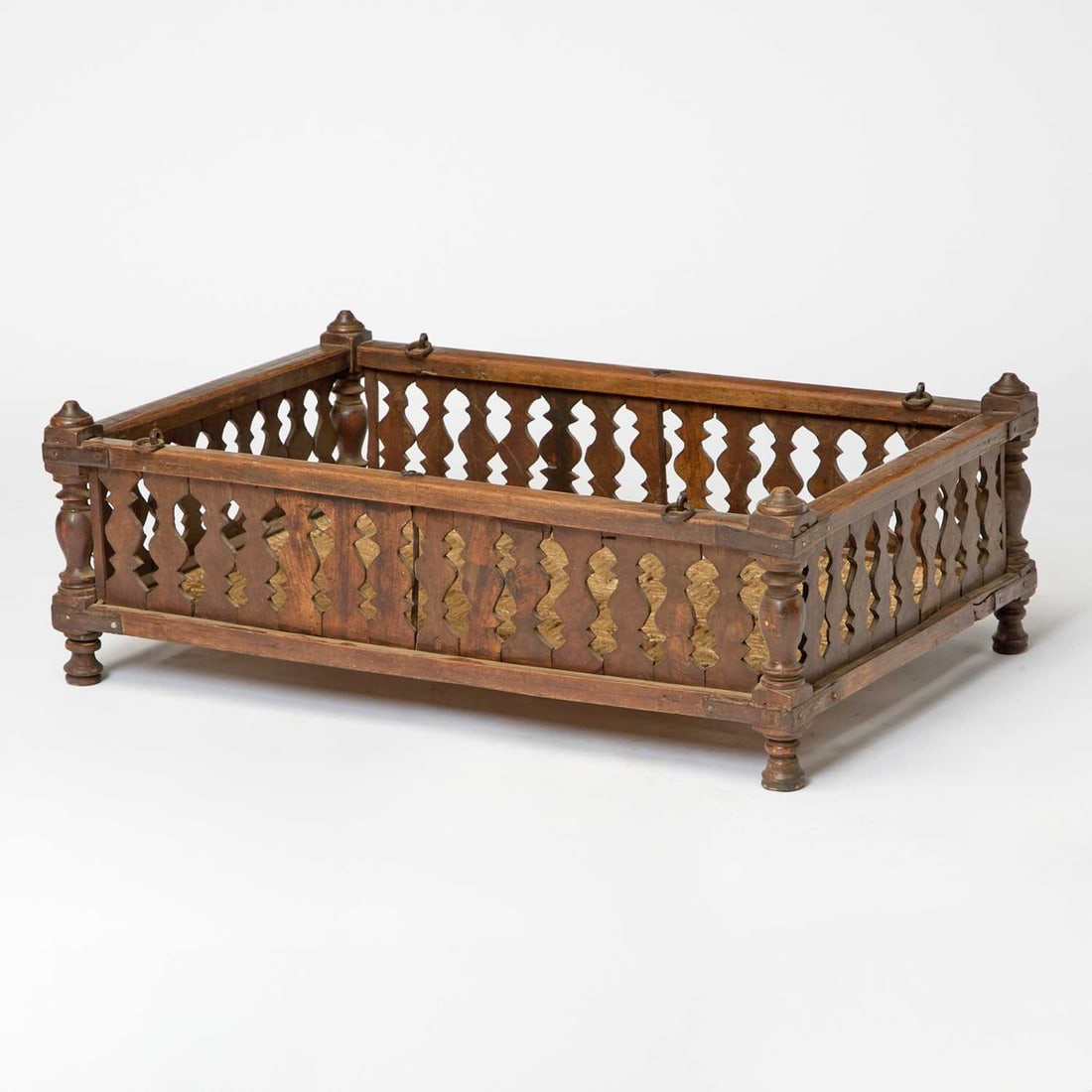 Indian Stained Wood and Iron Jhoola Swing: 19th century Height 11 1/4 inches, width 32 3/4 inches, depth 22 1/4 inches Shrinkage cracks to pierced borders, overall with scratches, gauges, chips to finials and feet, oxidation and rust to iron h