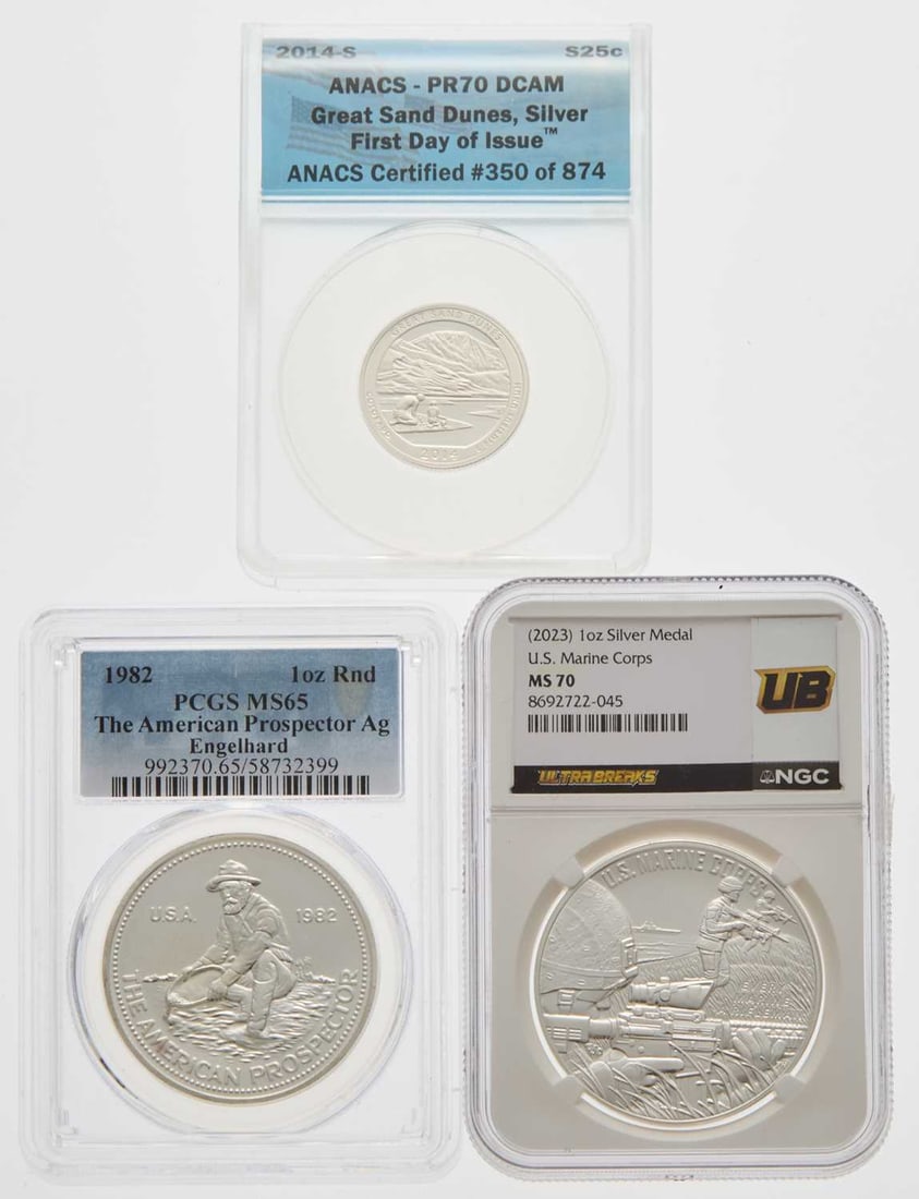 United States. Group of Third-Party Certified Silver Issues.: Three pieces, including: A first-year-of-issue Englehard Prospector round, dated 1982. PCGS MS-65. 2014-S Great Sand Dunes American The Beautiful Silver Quarter. ANACS PR-70 DCAM. 2023 U.S. Marine Cor