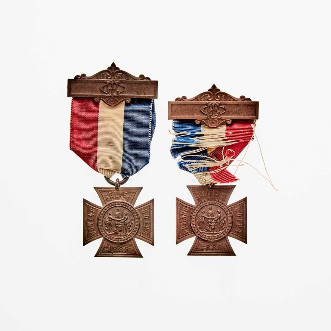 United States. Pair of 1883-dated (c. 1886) Grand Army of the Republic Women's Relief Corps Medals.: Two pieces. Medal and top bar both bronze. OBV: Women's Relief Corps logo inside a cross patee, with WOMEN'S RELIEF CORPS and date on the arms. REV: Text reading "PATENTED / MAY 4. AND SEPT. 28, 1886 