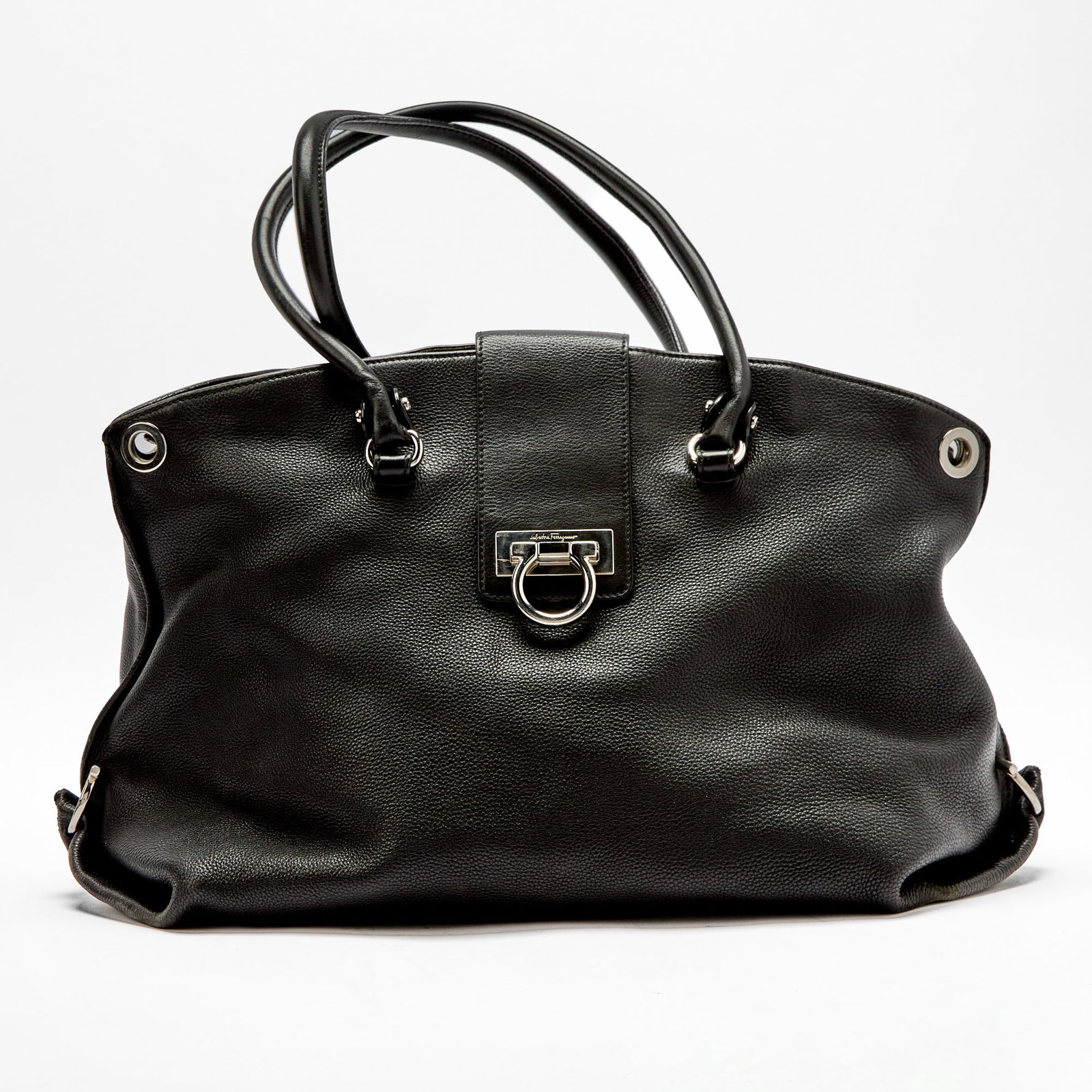 Salvatore Ferragamo Black Leather Bag: Dual top handles with silver-tone hardware, front flap closure with Gancini emblem, zip top opening, black monogram fabric interior with side zippered pocket and side slip pockets, reverse with outsid