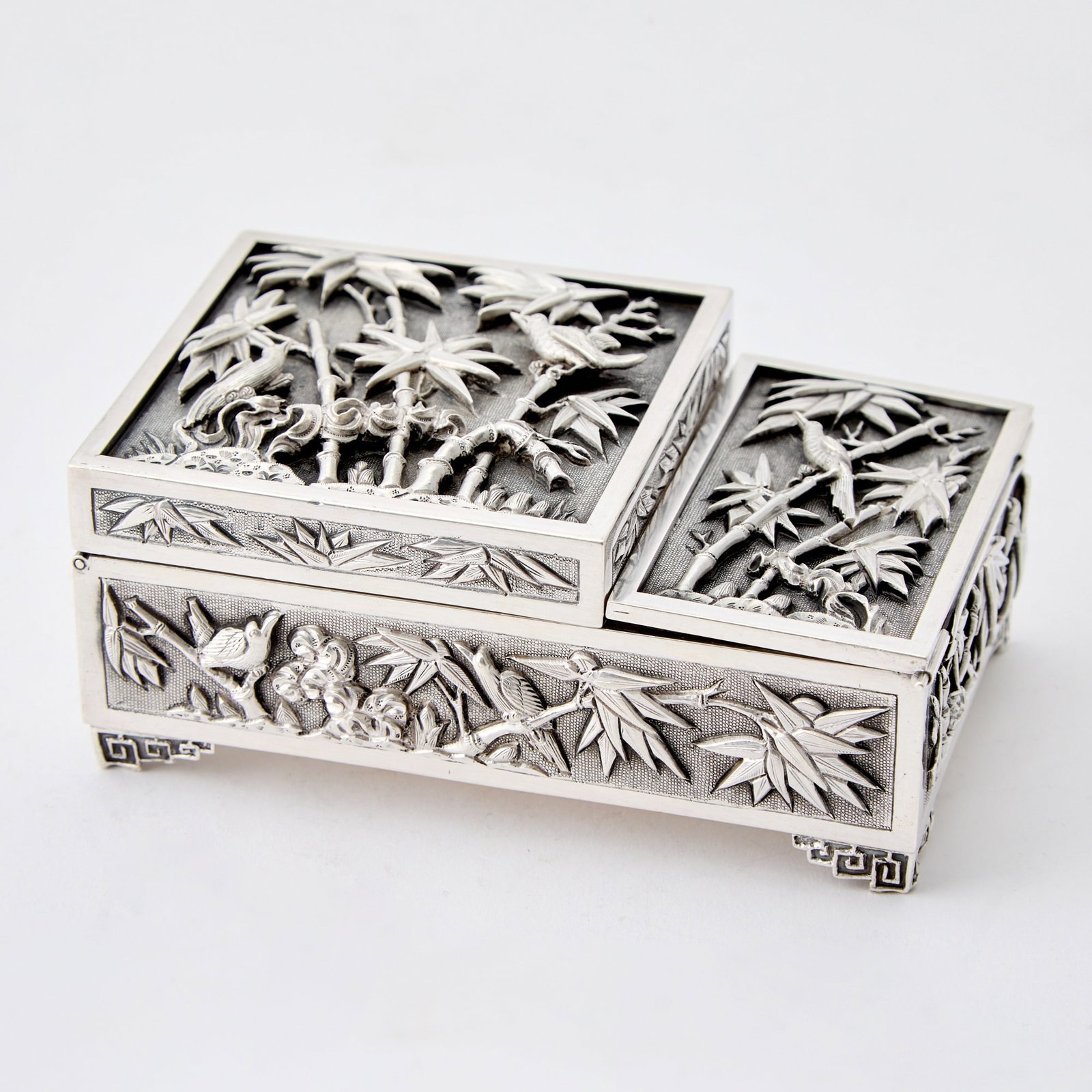 Chinese Export Silver Smoking Set: 1920s/1930s Rectangular with two hinged covers, decorated with birds and bamboo in high relief, interior with a mirror. Length 5 inches, approximately 19 ounces, all in. Interior of larger cover with 