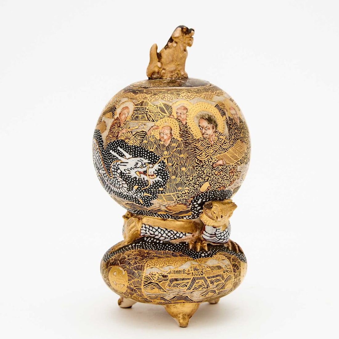 A Japanese Satsuma Earthenware Koro and Cover Meiji Period: Of globular form and molded on a tripod stand with encircling dragons; the pierced cover surmounted by shishi; signed Satsuma Hododa with Shimazu mark. (Height 5 1/2 inches) Slight wear to enamel; a m