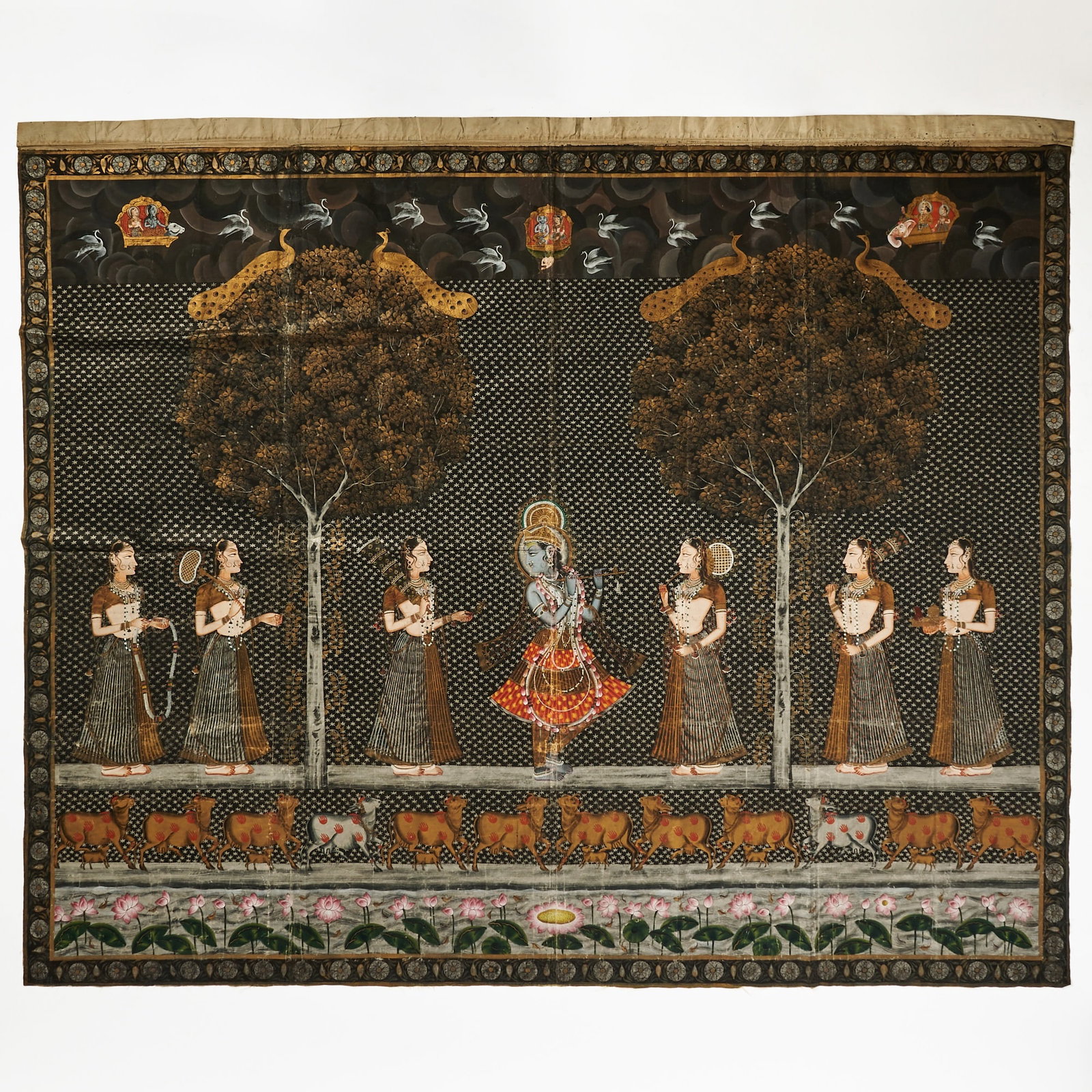 Indian Silk Pictorial Textile Panel Depicting a Traditional Indian Pichwai Painting: Late 20th century Featuring the Hindu deity Lord Krishna, as the central figure, with blue skin, representing his divine cosmic nature, standing in his traditional tribhanga posture, holding a bansuri