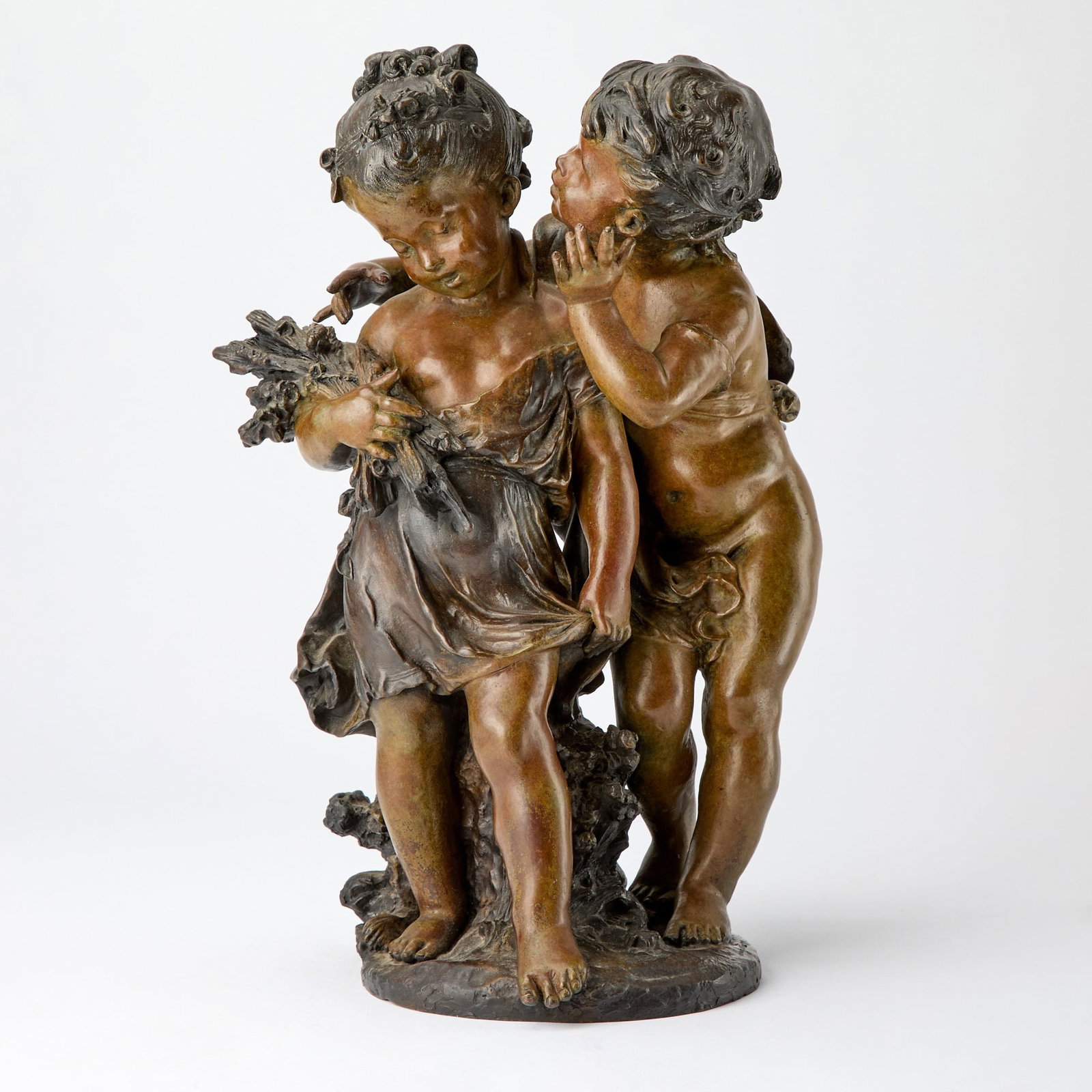 Patinated Bronze Figural Group Titled "The Secret": After Auguste Moreau, 20th century Modeled as a young boy and girl in a playful pose, signed in casting with a foundry seal reading “Fabrication Francaise / Made in France / Paris.” Height