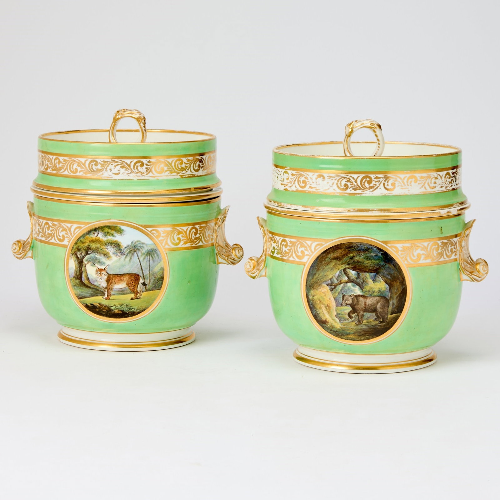 Pair of Derby Porcelain Apple-Green Ground Ice Pails, Covers and Liners: Circa 1800 Each bucket-shaped bowl finely painted with exotic animals in landscapes within circular gilt-lined cartouches superimposed on a band of trailing foliage flanked by shell handles, all