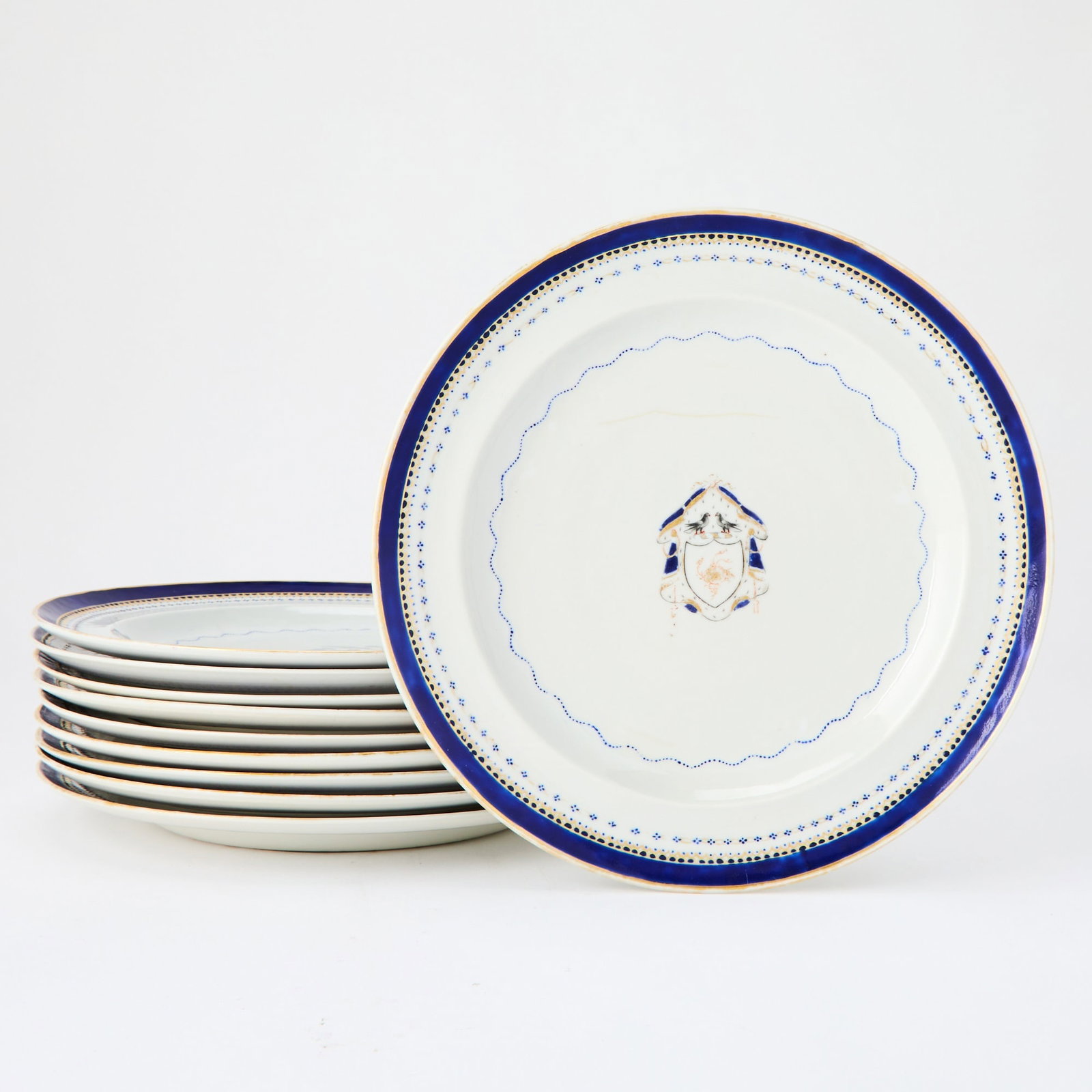 Set of Ten Chinese Export Porcelain Armorial Plates: 19th century Each with a central shield-shaped armorial within blue and gilt borders, gilt rim. Diameter 9 3/4 inches. Wear to gilded rims, armorials and borders; one with 6-inch haircrack to center. 