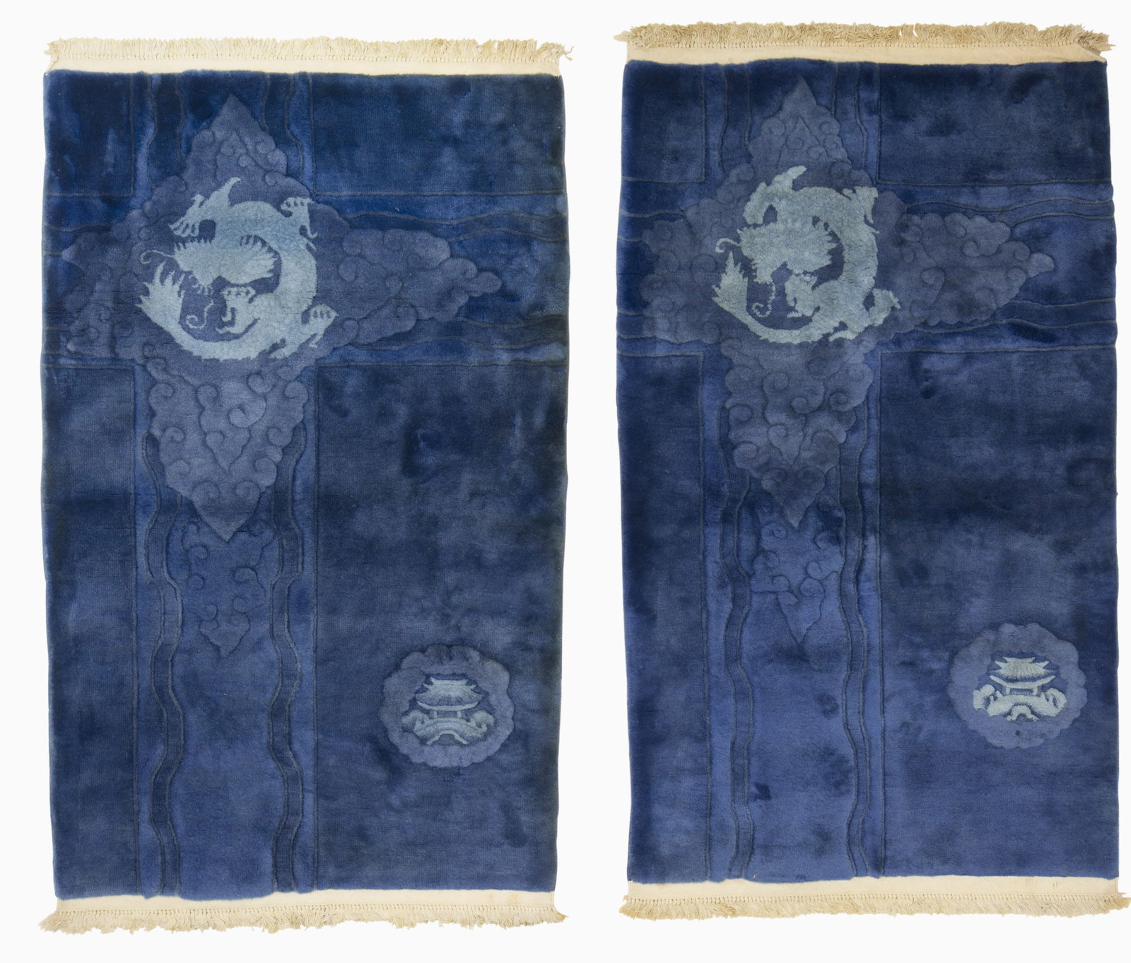 Pair of Nichols Chinese Rugs: China, Circa 1925 Each having a pagoda and dragon in the clouds above on an indigo field. (4' 8" x 3' 0" and 4' 8" x 2' 10") Soiled