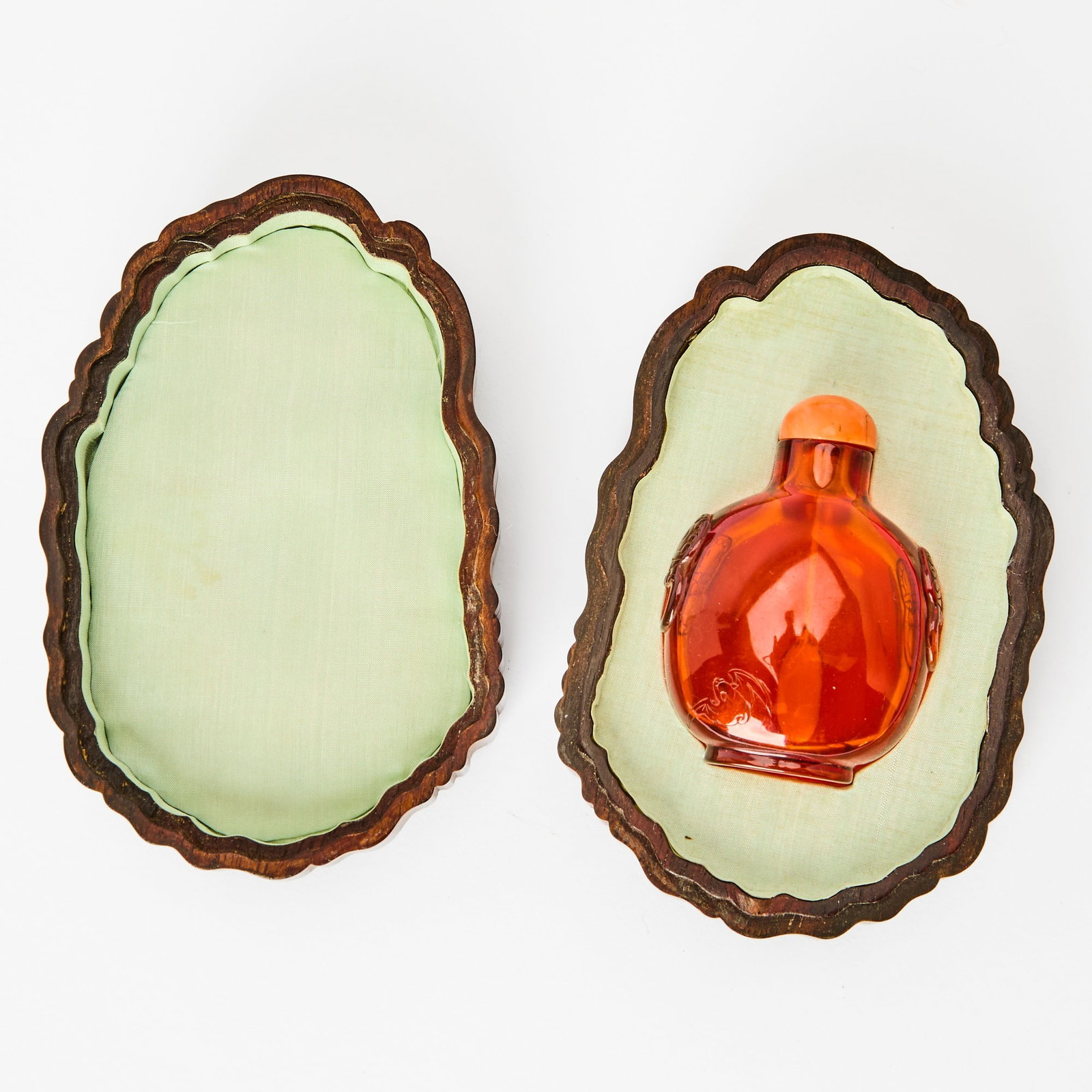 A Chinese Carved Amber Snuff Bottle with a Zitan Box Qing Dynasty: Of compressed ovoid form, carved with a pair of mythical beast masks to the sides, and a fu bat to the lower left of the body; the fitted box carved with double gourds borne on leafy vines. (