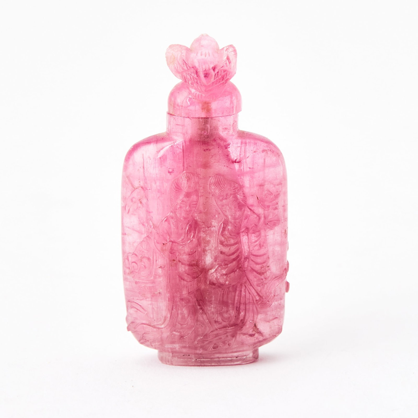 A Chinese Carved Pink Tourmaline Snuff Bottle 19th-20th Century: Of flattened form, carved in relief to show celestial figures, the stopped carved in the form of a bird. (Height 2 inches)