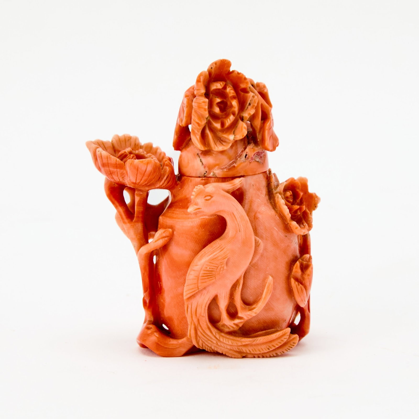 A Chinese Carved Coral Snuff Bottle 19th Century: Of ovoid form, encircled by a high-relief design of a phoenix and blossoming branches. (Height 2 3/4 inches)