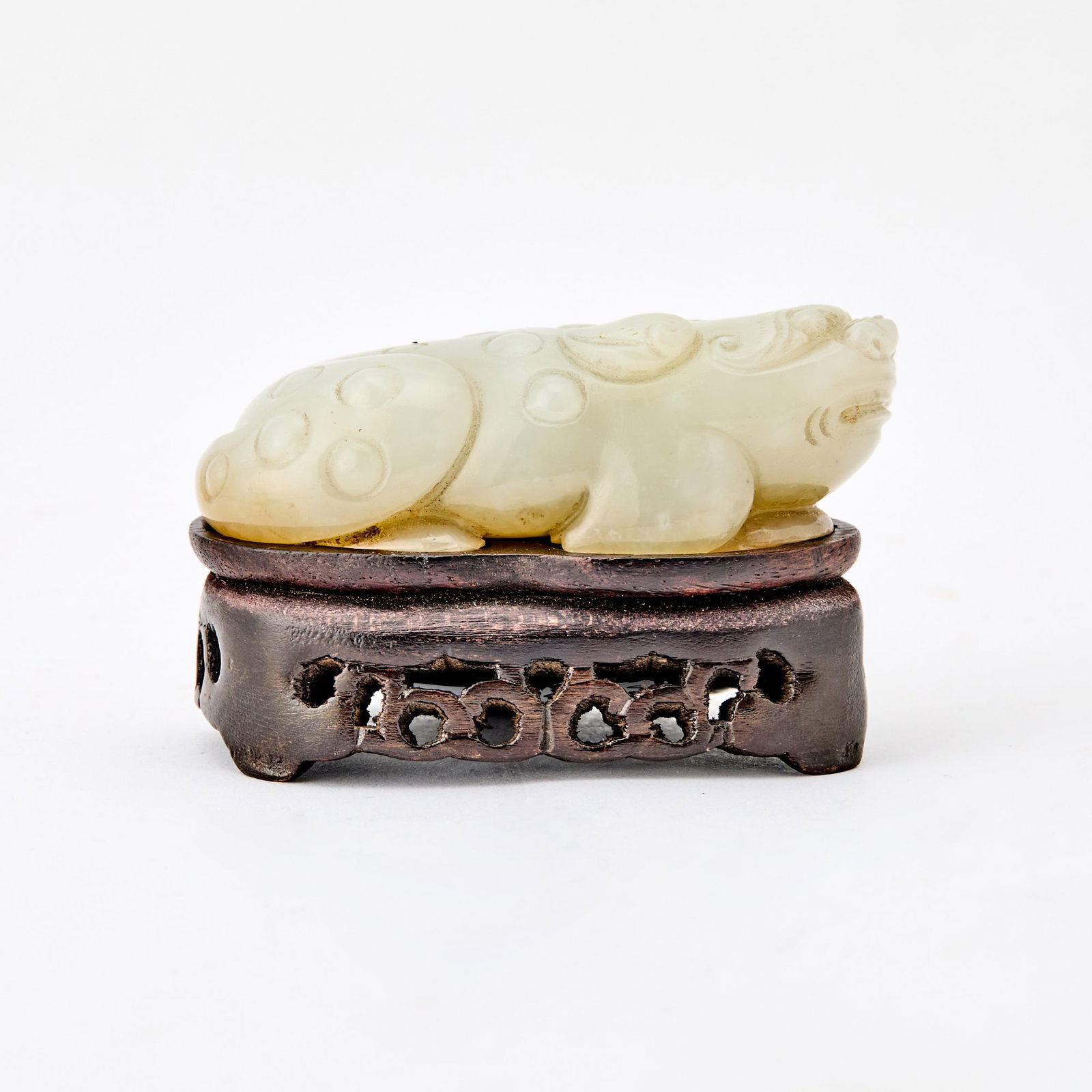 A Chinese Carved Celadon Jade Three-Legged Toad Ming-Qing Dynasty: Carved as a recumbent, warty figure with its head slightly raised. (Length 3 1/4 inches)